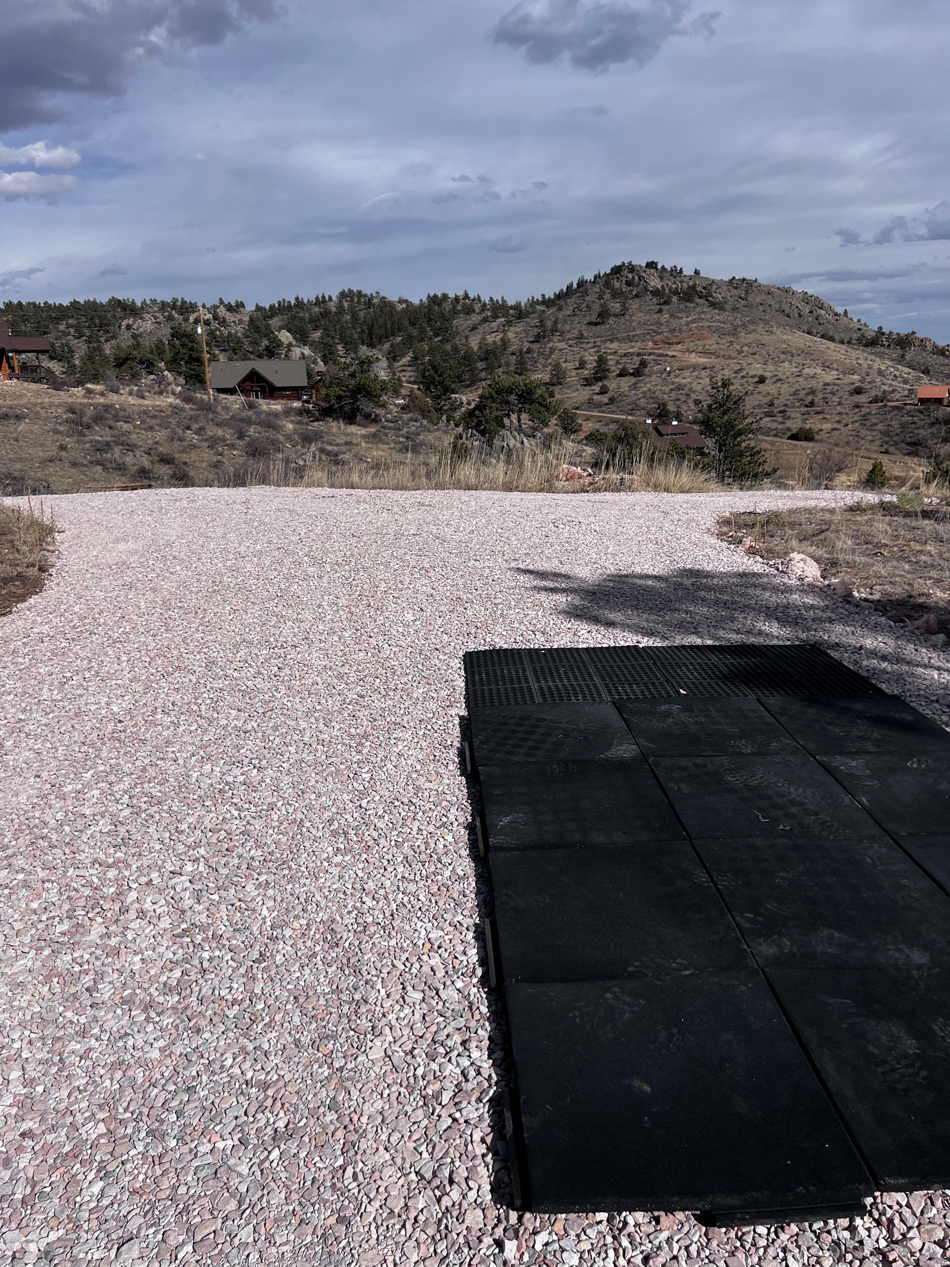 Completed septic system cover with gravel surface in mountain setting