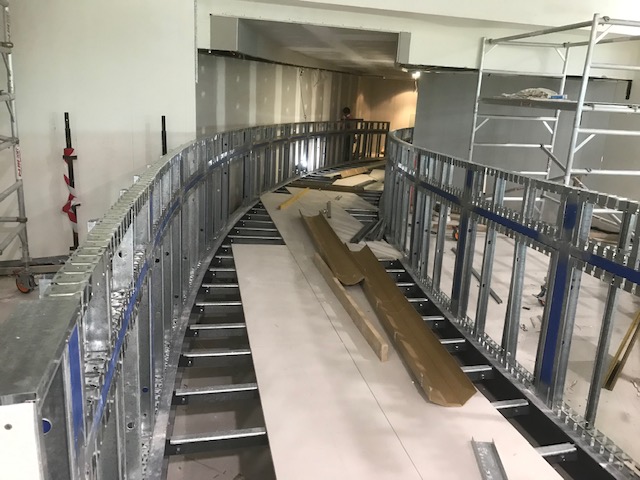 Curved steel framing along an interior stairway