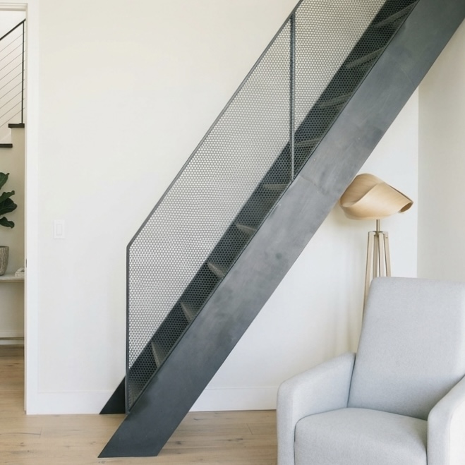 Blackened steel staircase with perforated metal railing