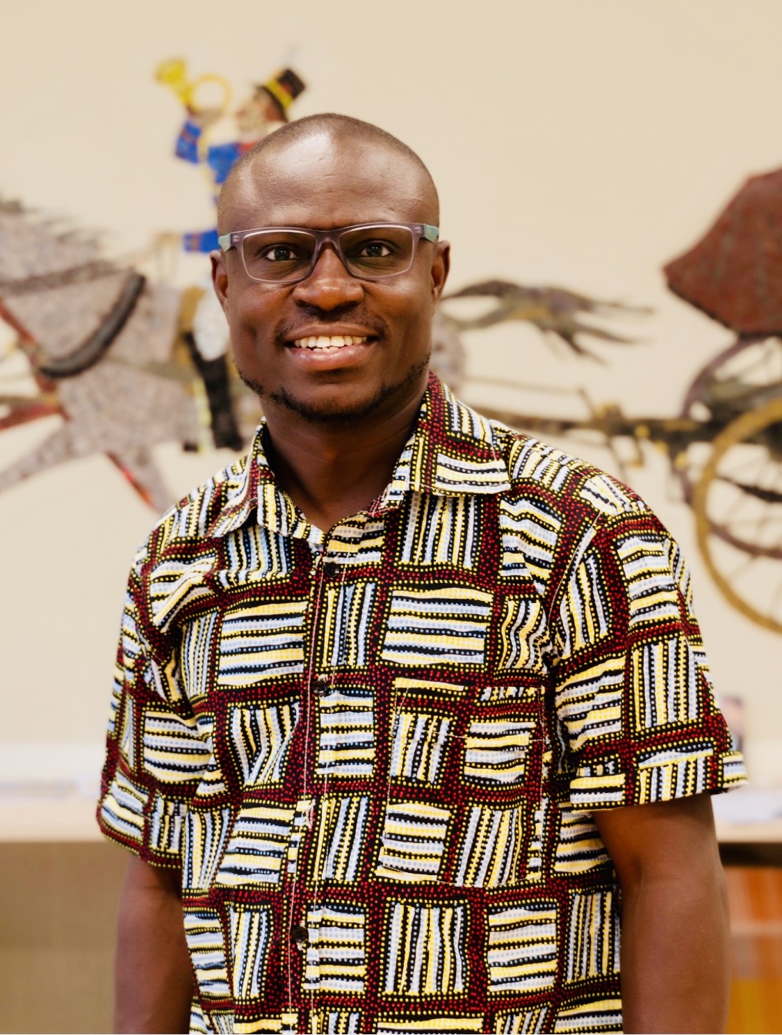 Dr. Rueben Okine wearing a patterned shirt in an arts and community setting