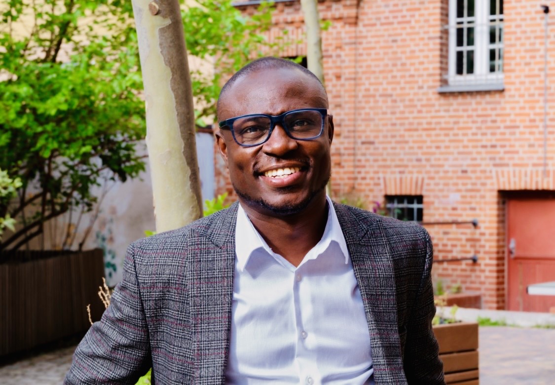 Dr. Rueben Okine seated outdoors in Berlin
