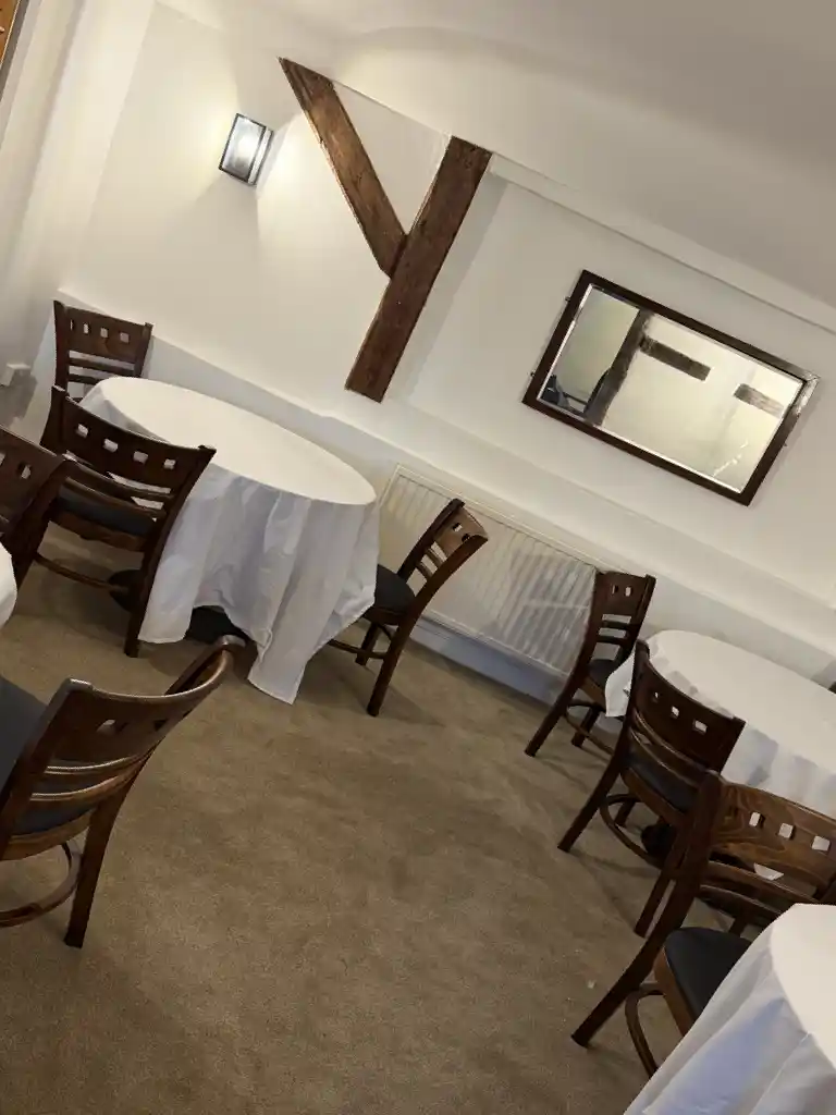 Function room with white linens and oak beams