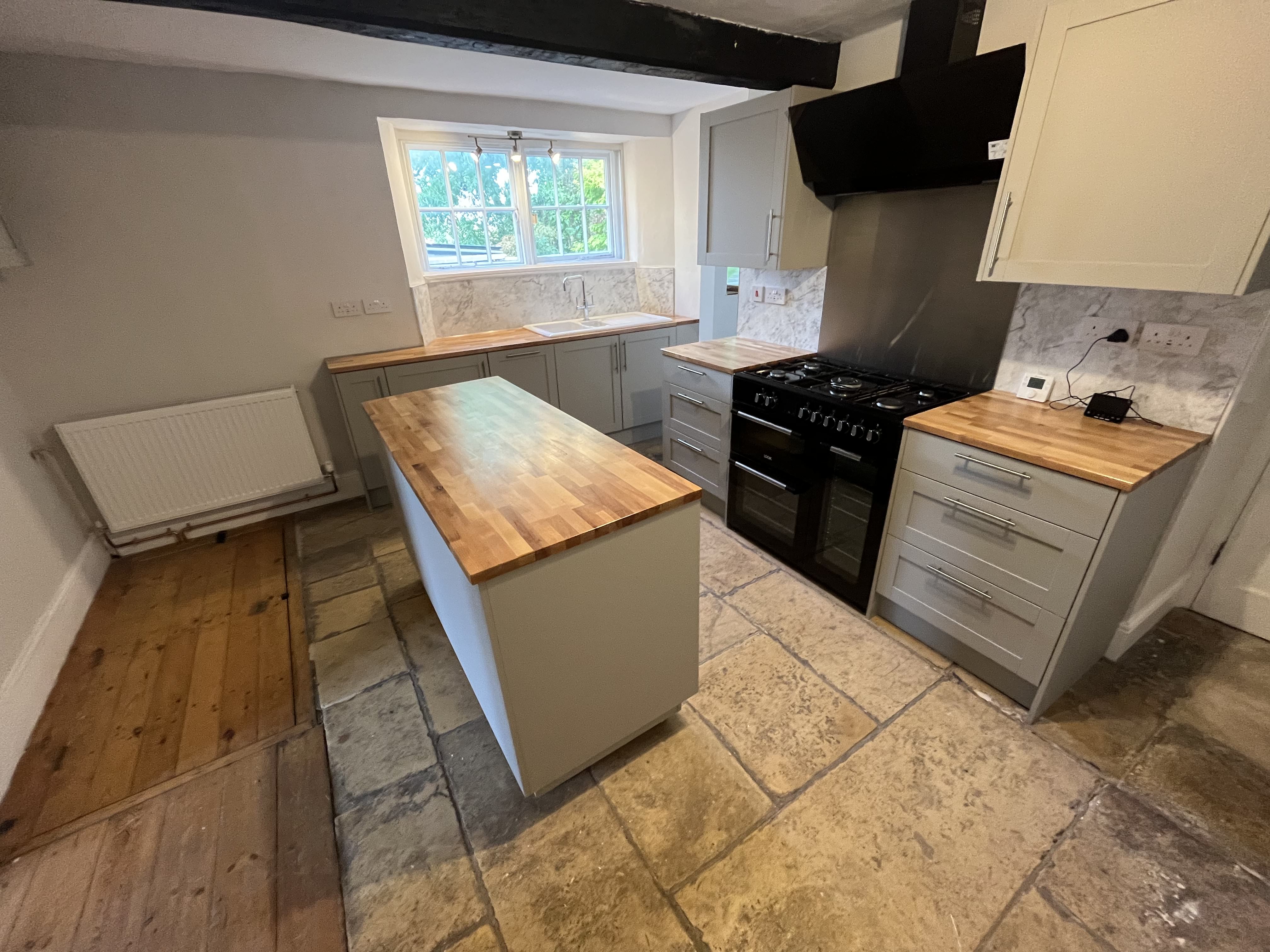 Completed pale grey shaker kitchen with oak worktops