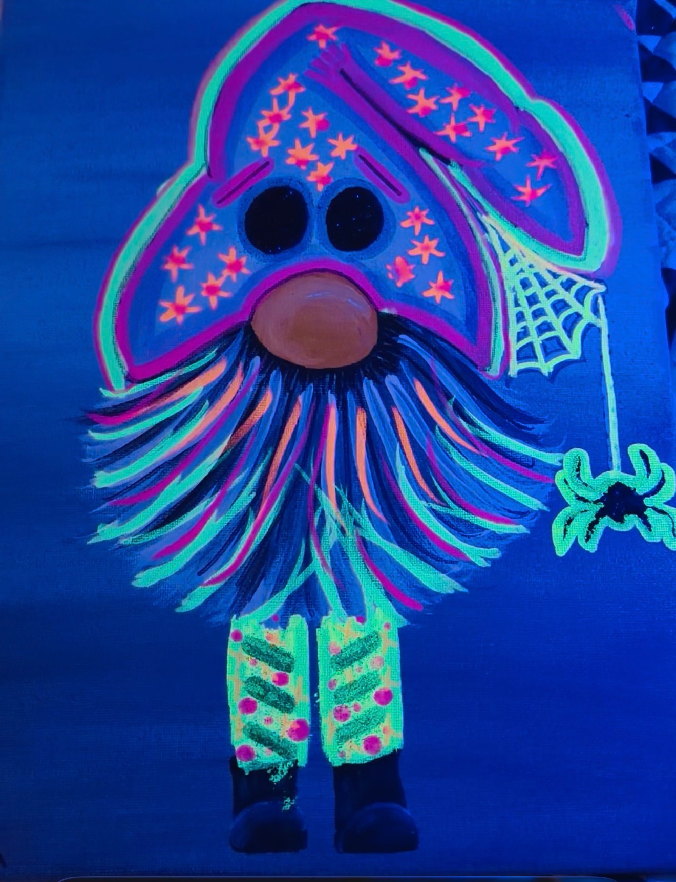 Hand-painted Halloween gnome glowing under blue ultraviolet light