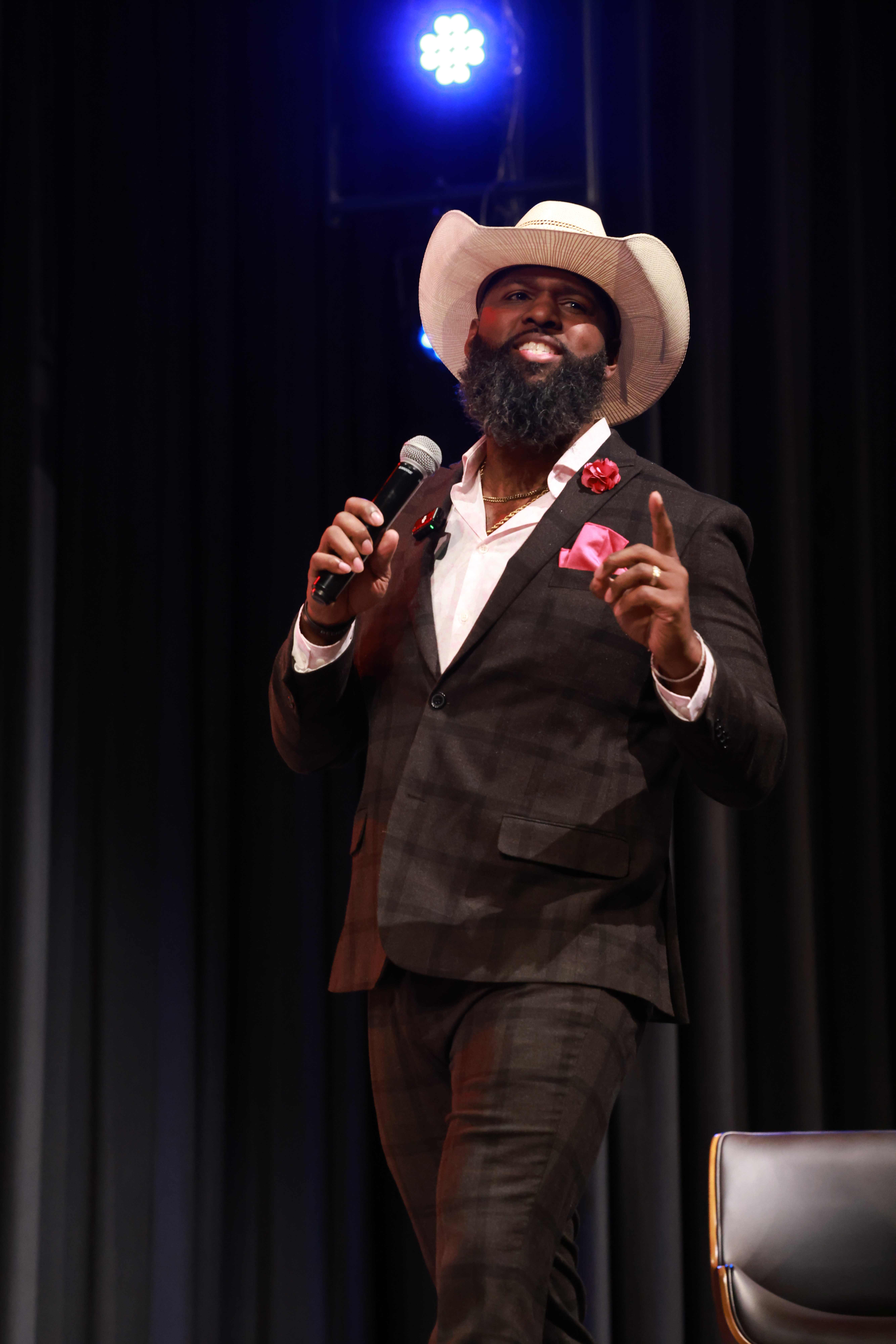 Andre Fluellen speaking under a spotlight at The Forge Event