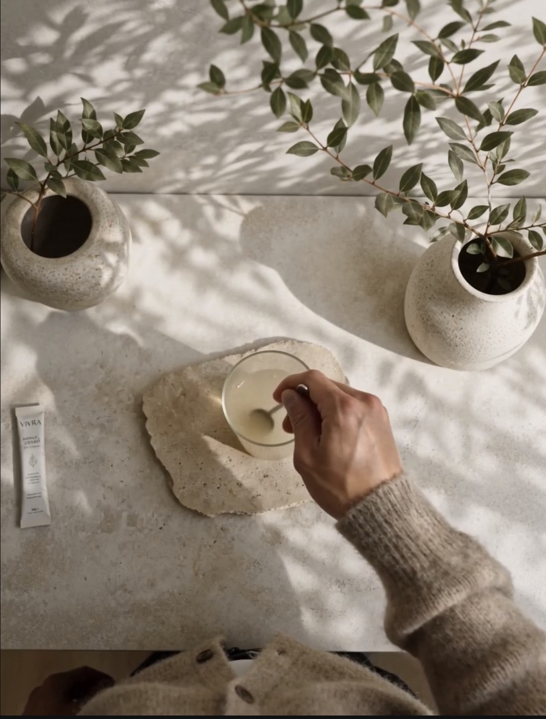 Overhead view of stirring a VIVRA sachet into a glass bowl