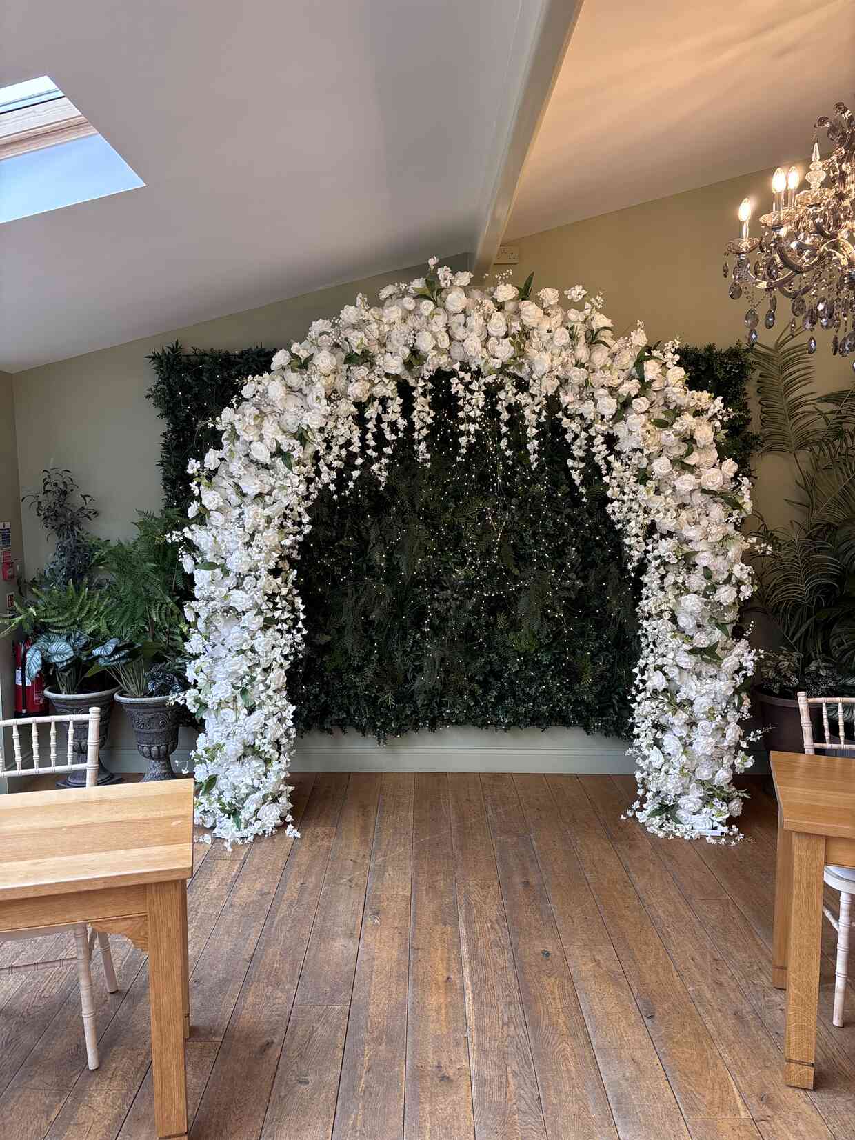 Stunning white floral arch with cascading roses and greenery