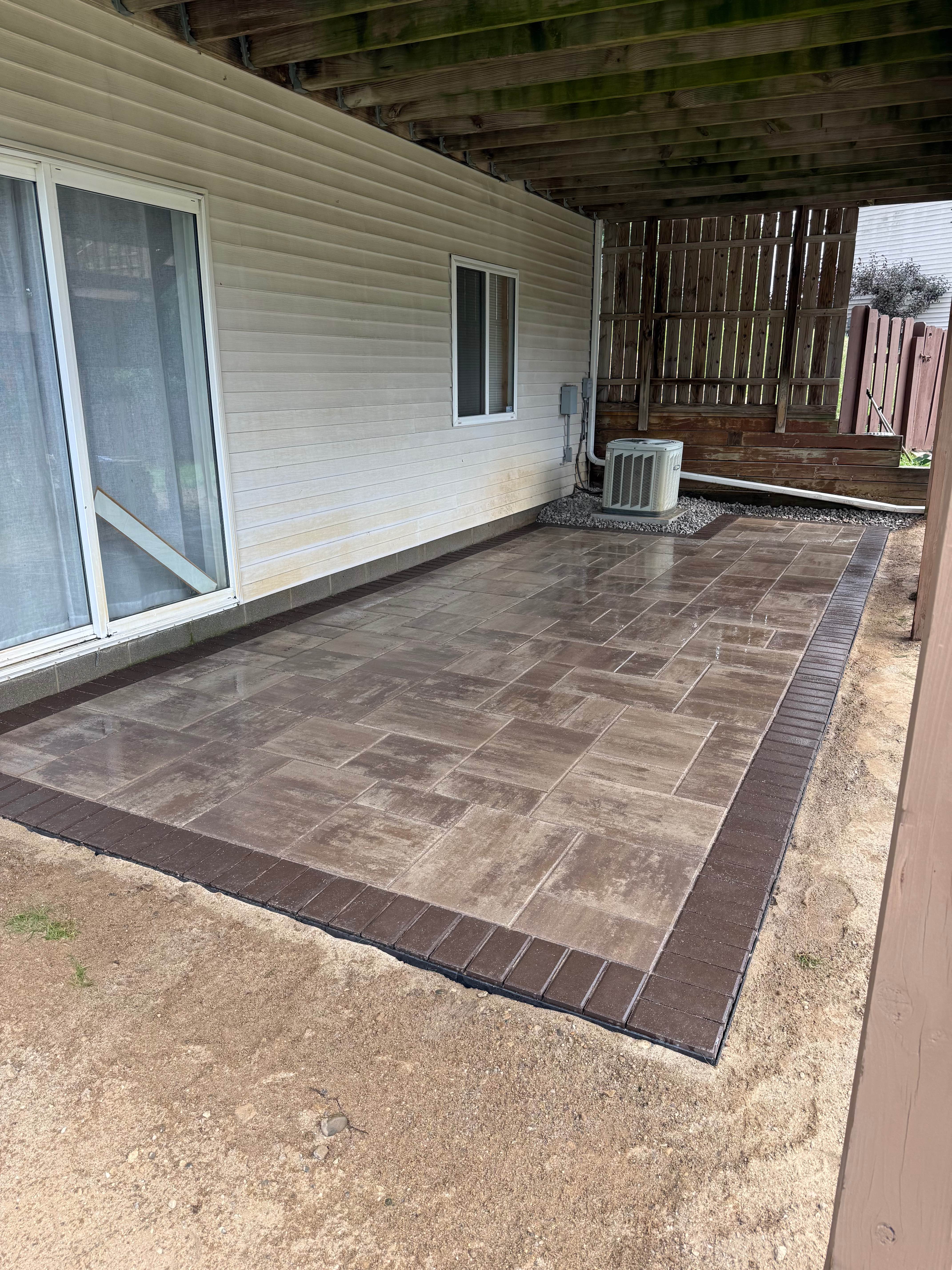 Full view of covered patio area with precision-laid pavers and border edging