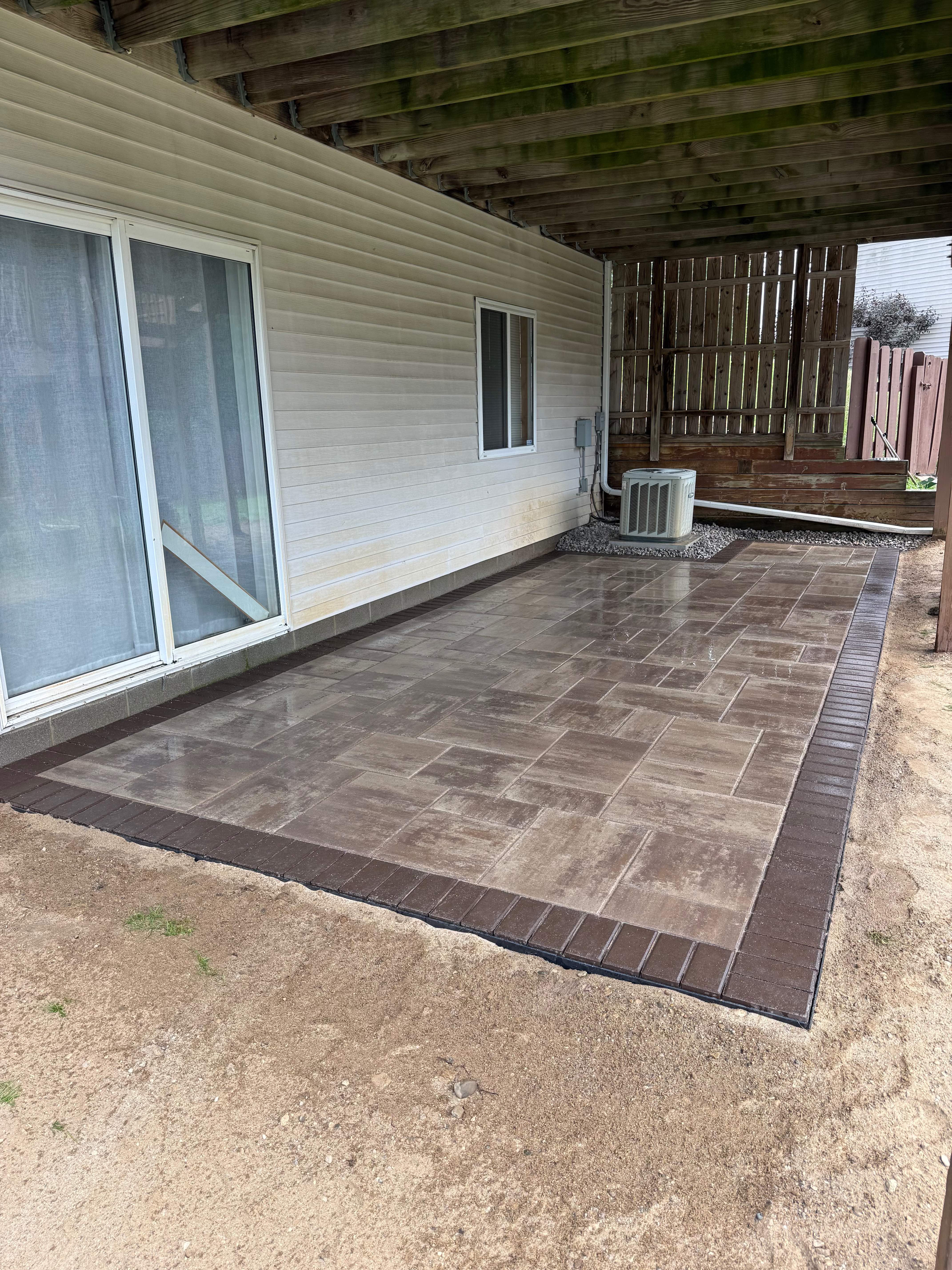 Wide angle of paver patio showing full scope of installation against home exterior