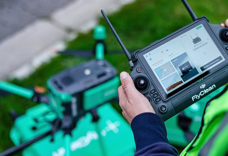 Drone de FlyClean realizando limpieza en fachada de edificio en altura