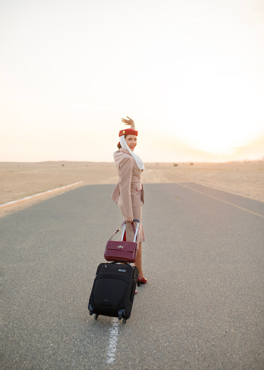 Juanita walking through the desert in Emirates uniform