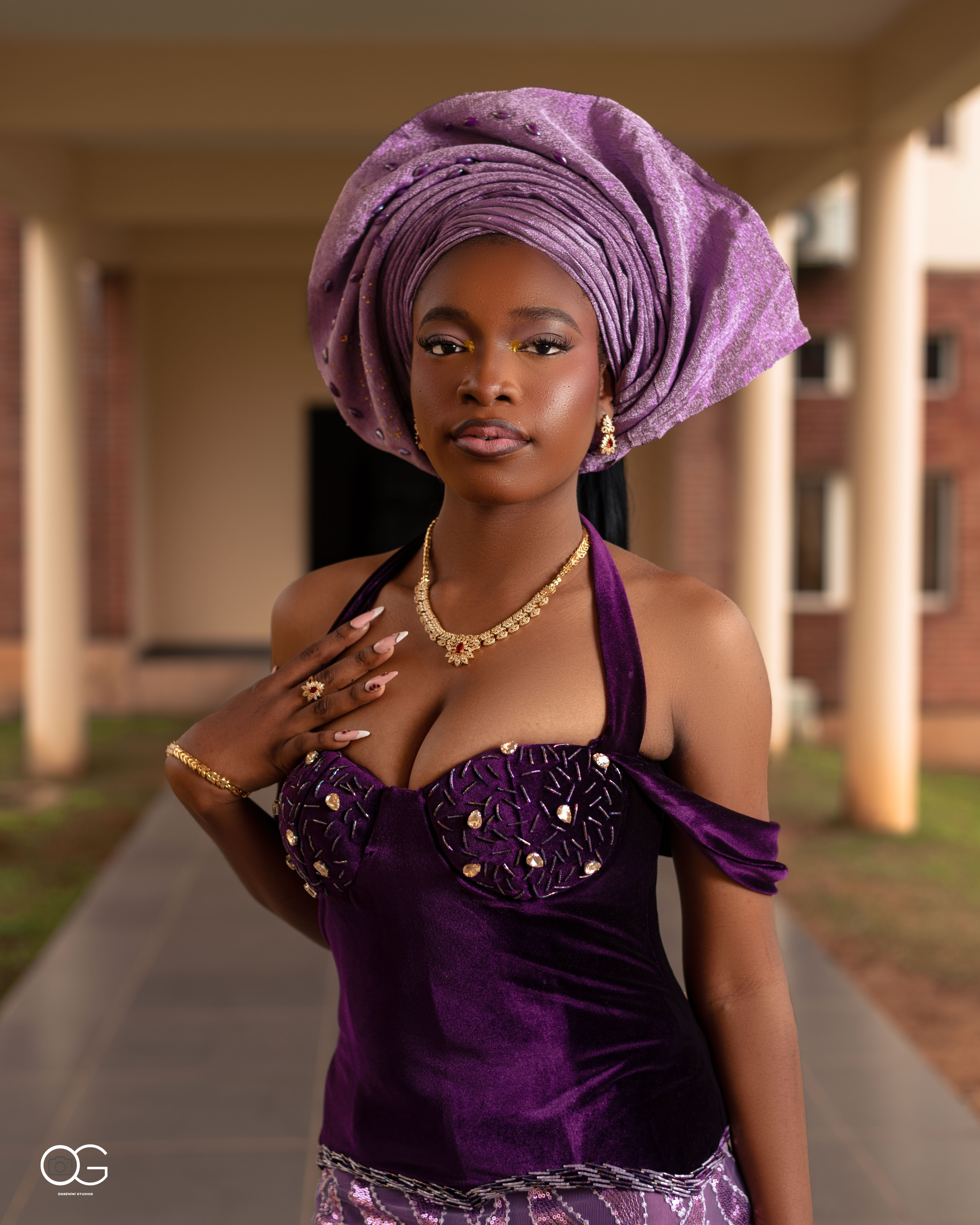 Graduate in a purple gele and embellished outfit