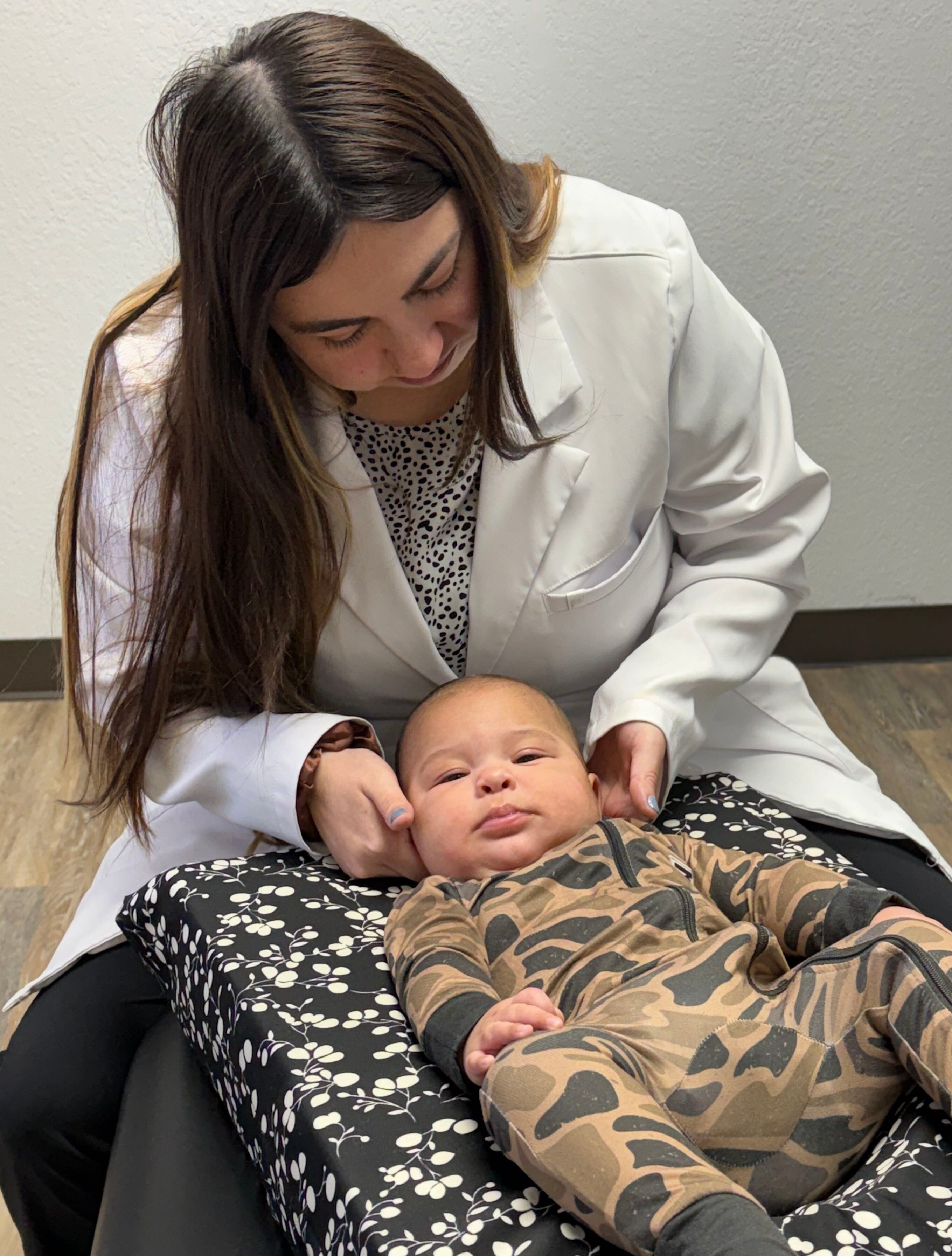 Doctor gently examining an infant during a pediatric chiropractic visit