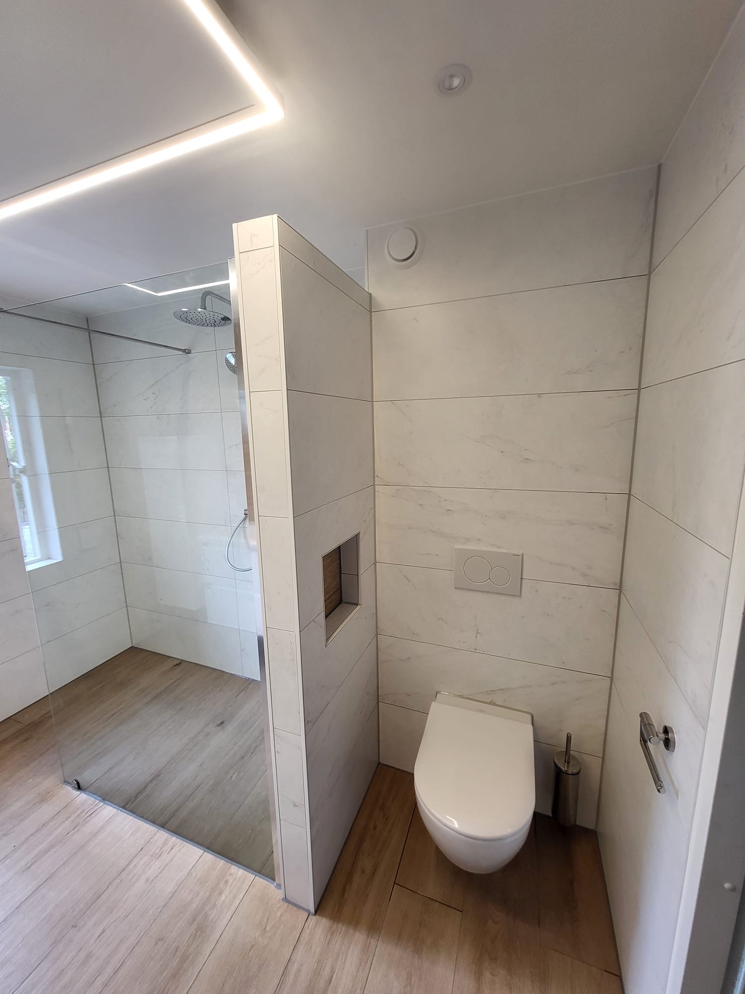 Hangtoilet en inloopdouche met witte marmerlook wandtegels en houtlook vloer