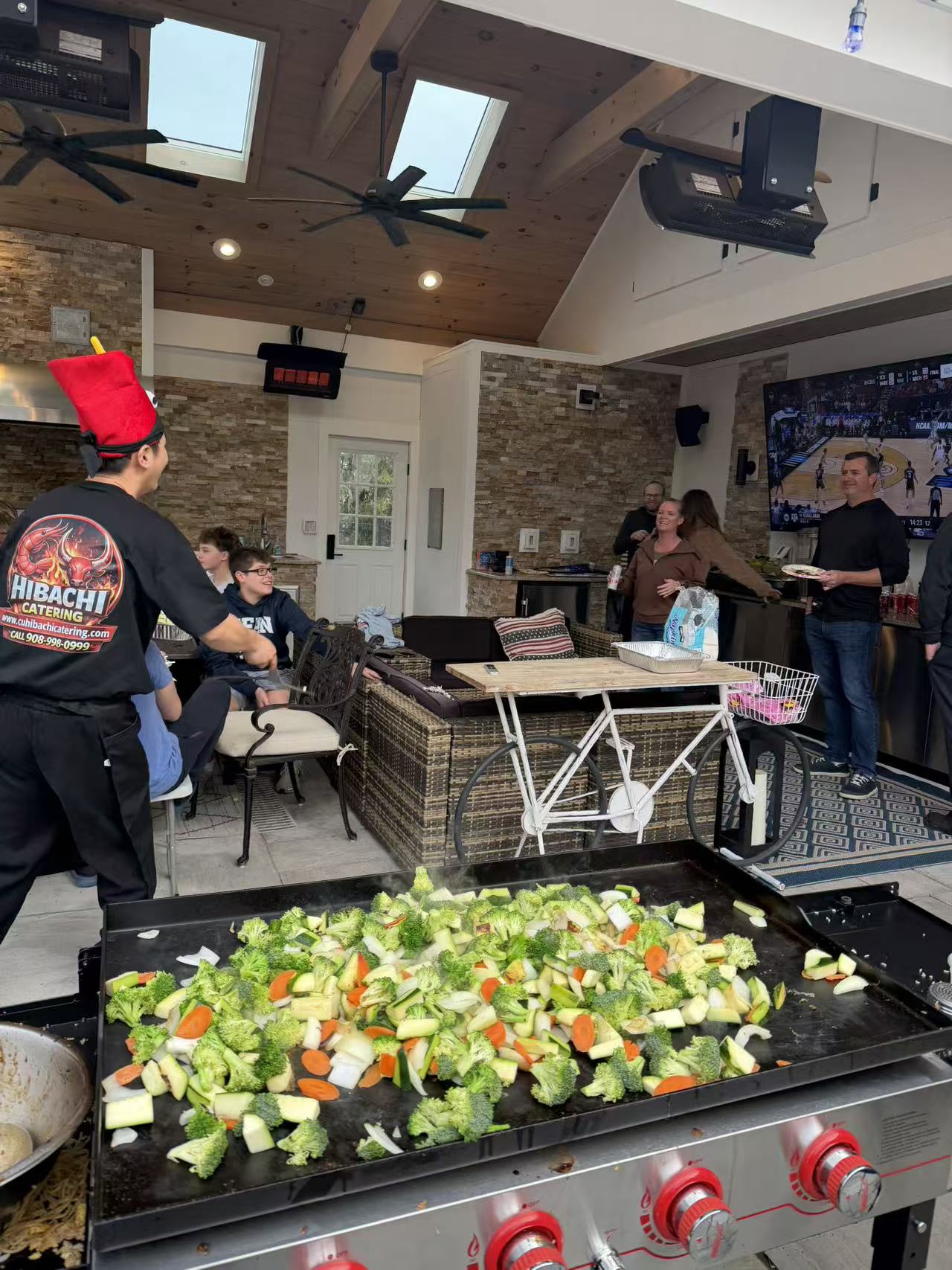 Hibachi chef cooking fresh vegetables on the grill at a family gathering