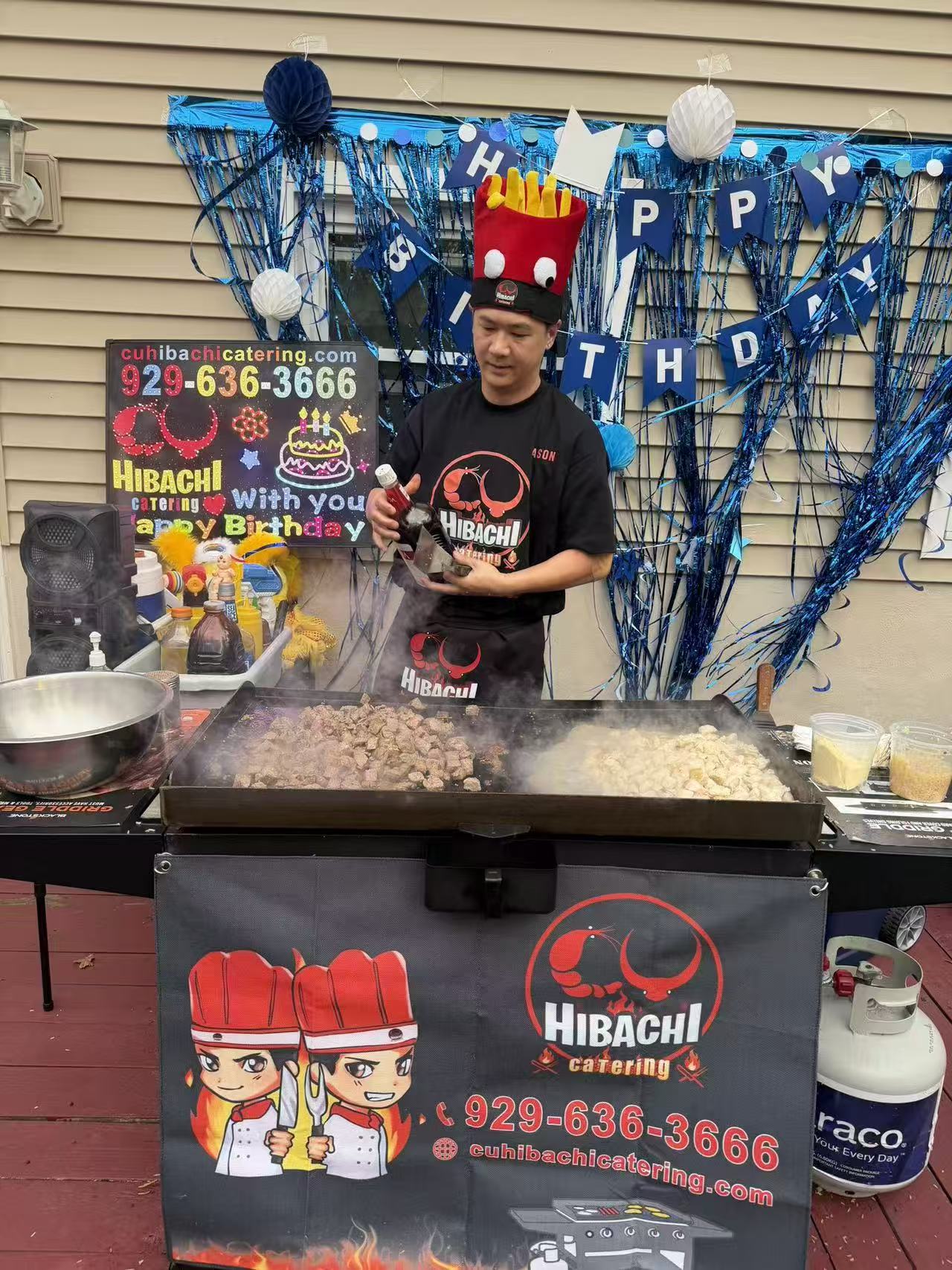 Chef cooking at birthday party with blue decorations and branded grill setup
