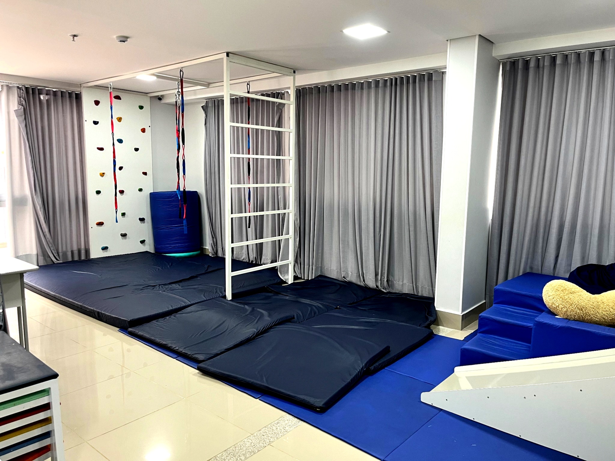 Sala de psicomotricidade com parede de escalada e equipamentos terapêuticos