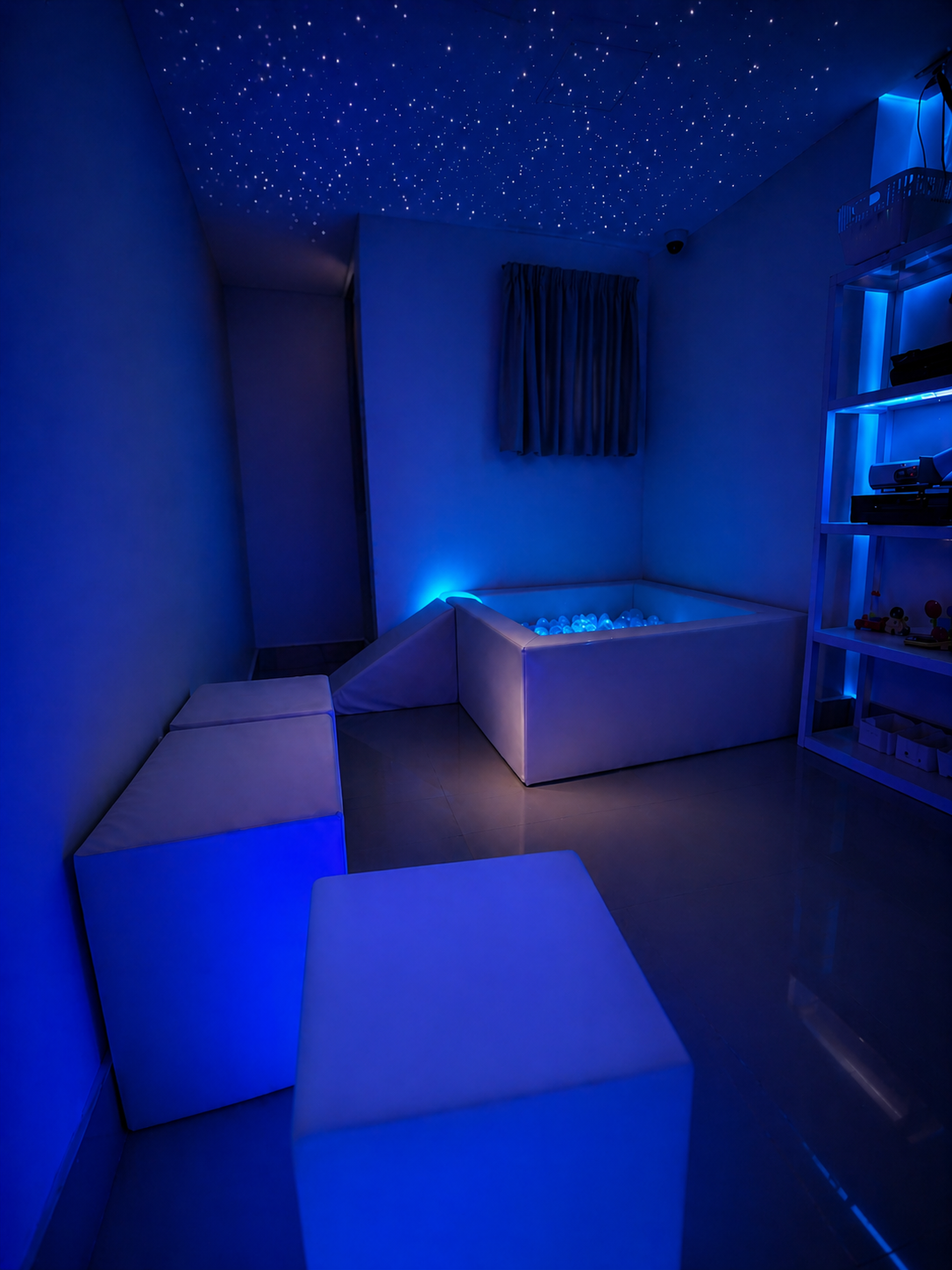 Sala Snoezelen multissensorial com iluminação azul e teto estrelado