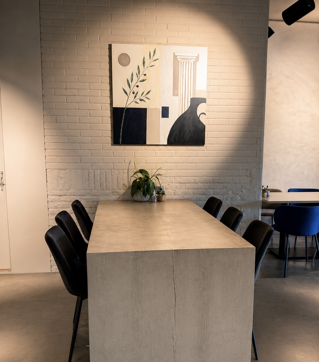 Dining area with communal table and modern artwork
