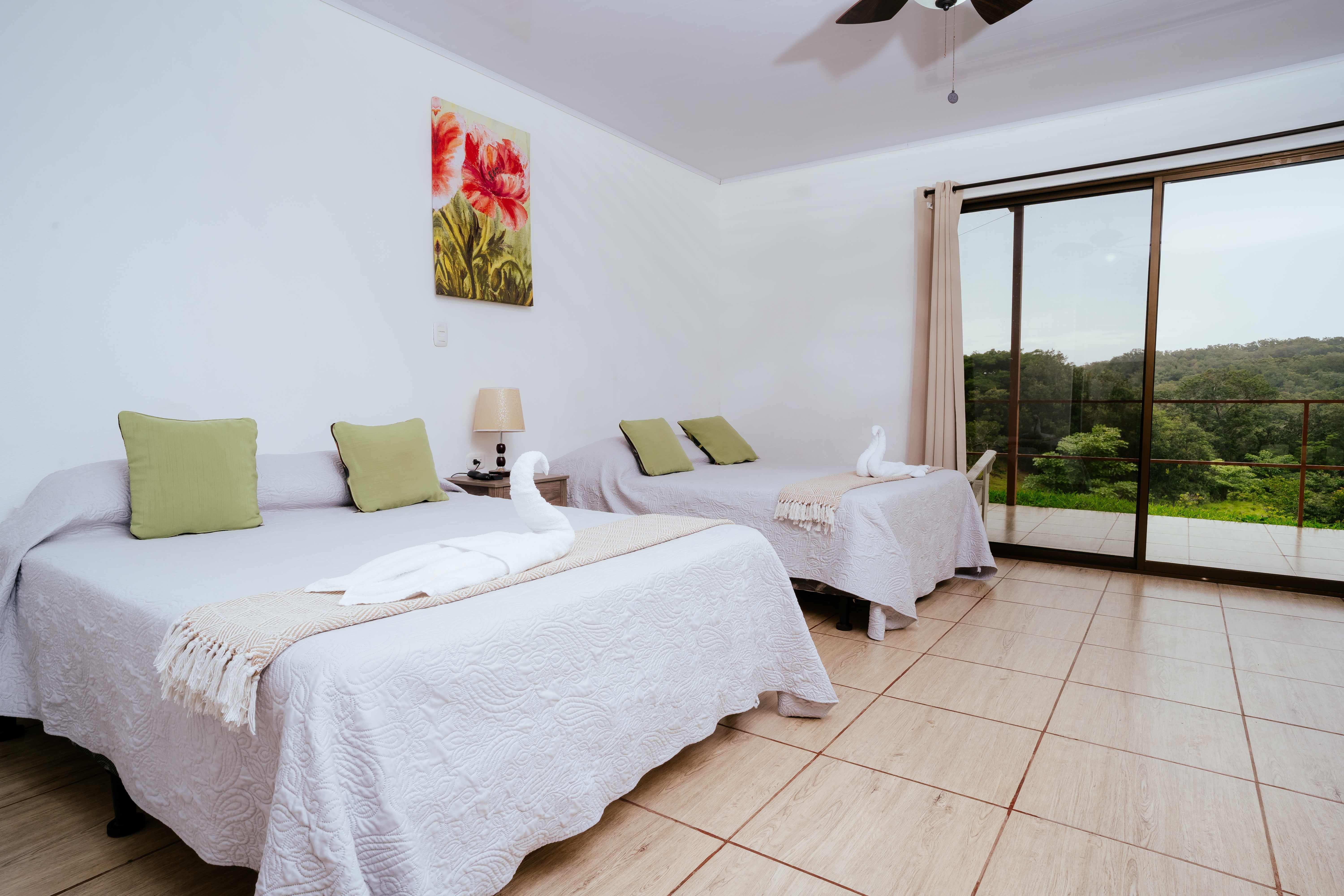 Studio apartment bedroom with two double beds and balcony mountain views