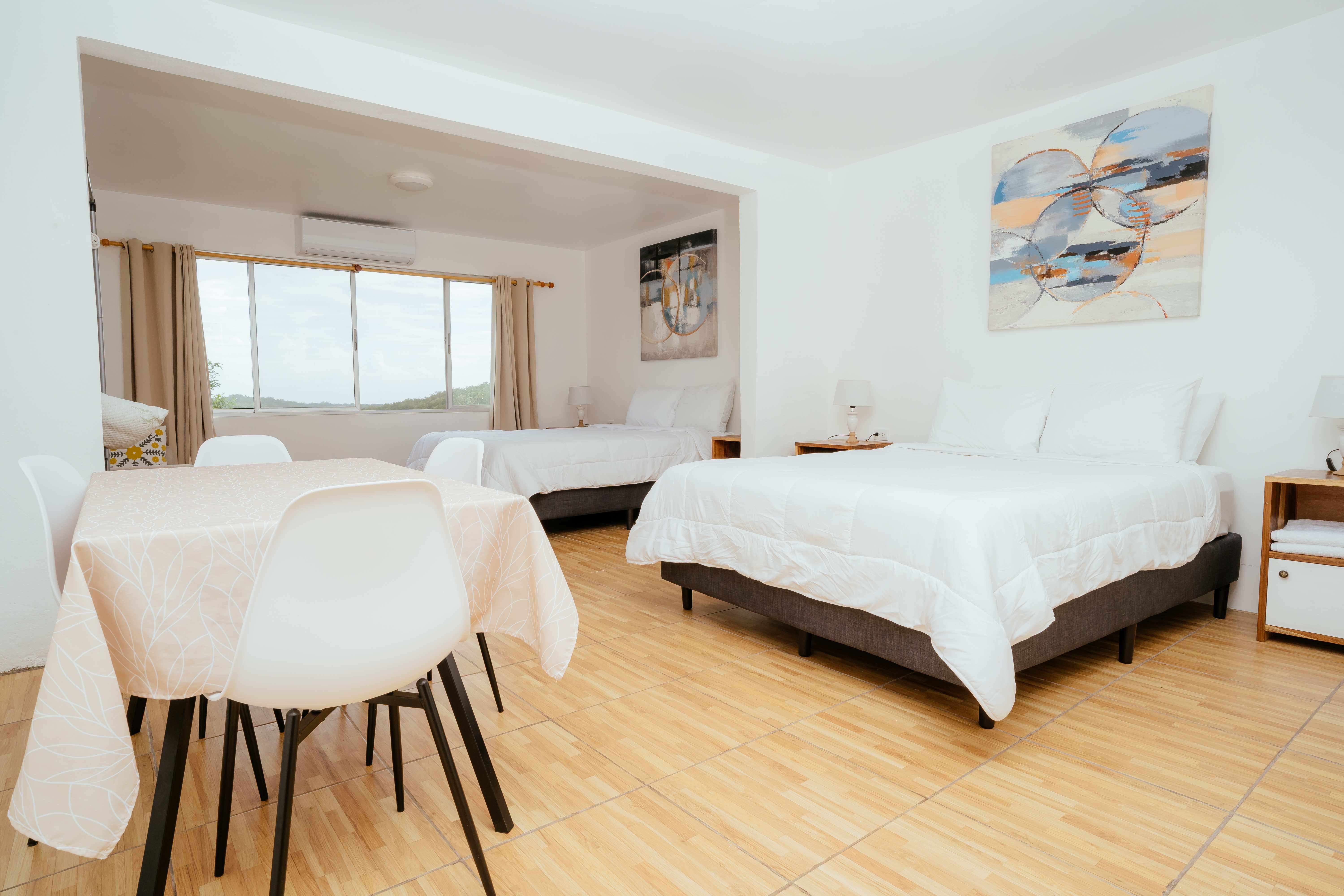 Spacious deluxe studio with dining area, multiple beds, and mountain views