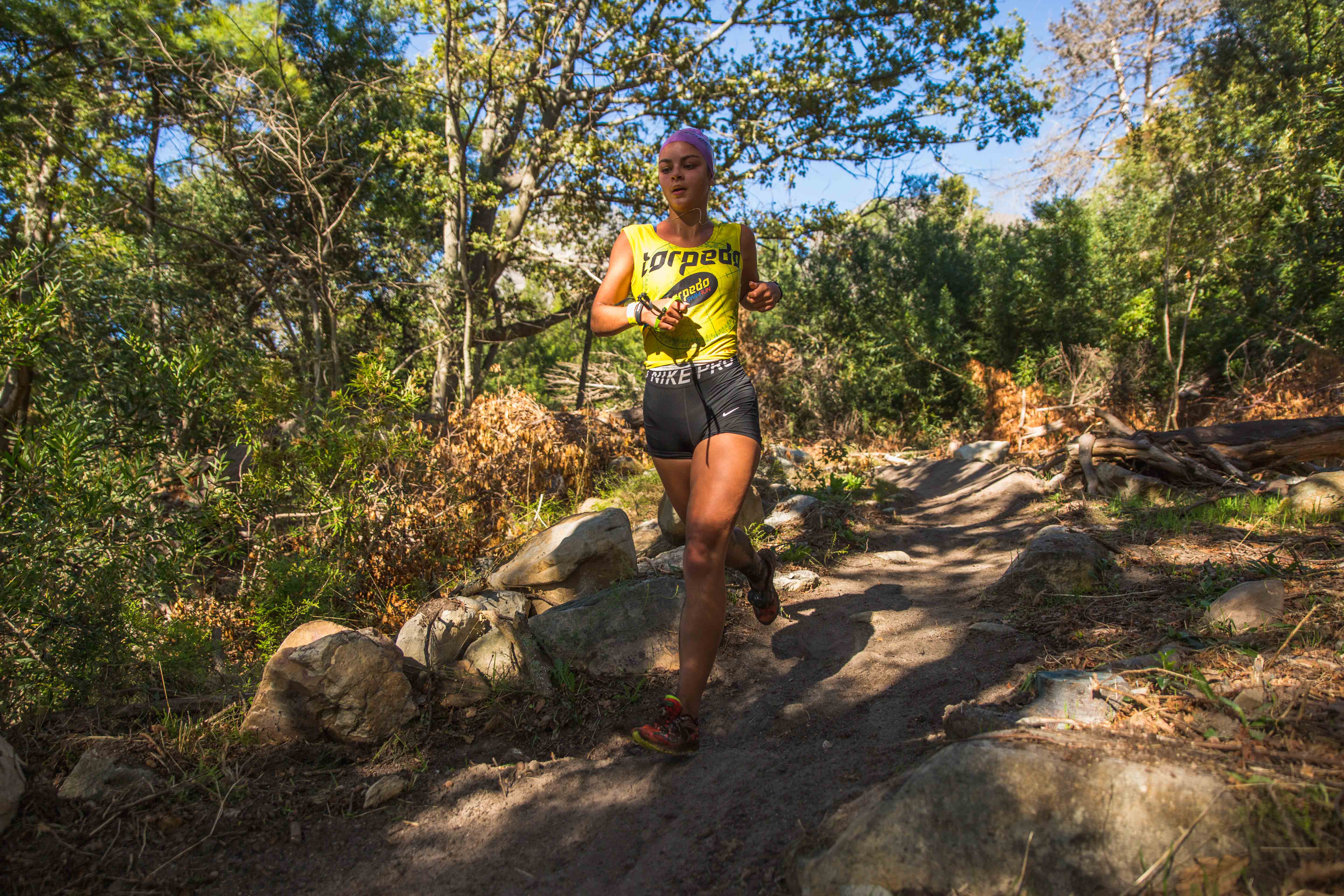 Athlete running on rocky forest trail