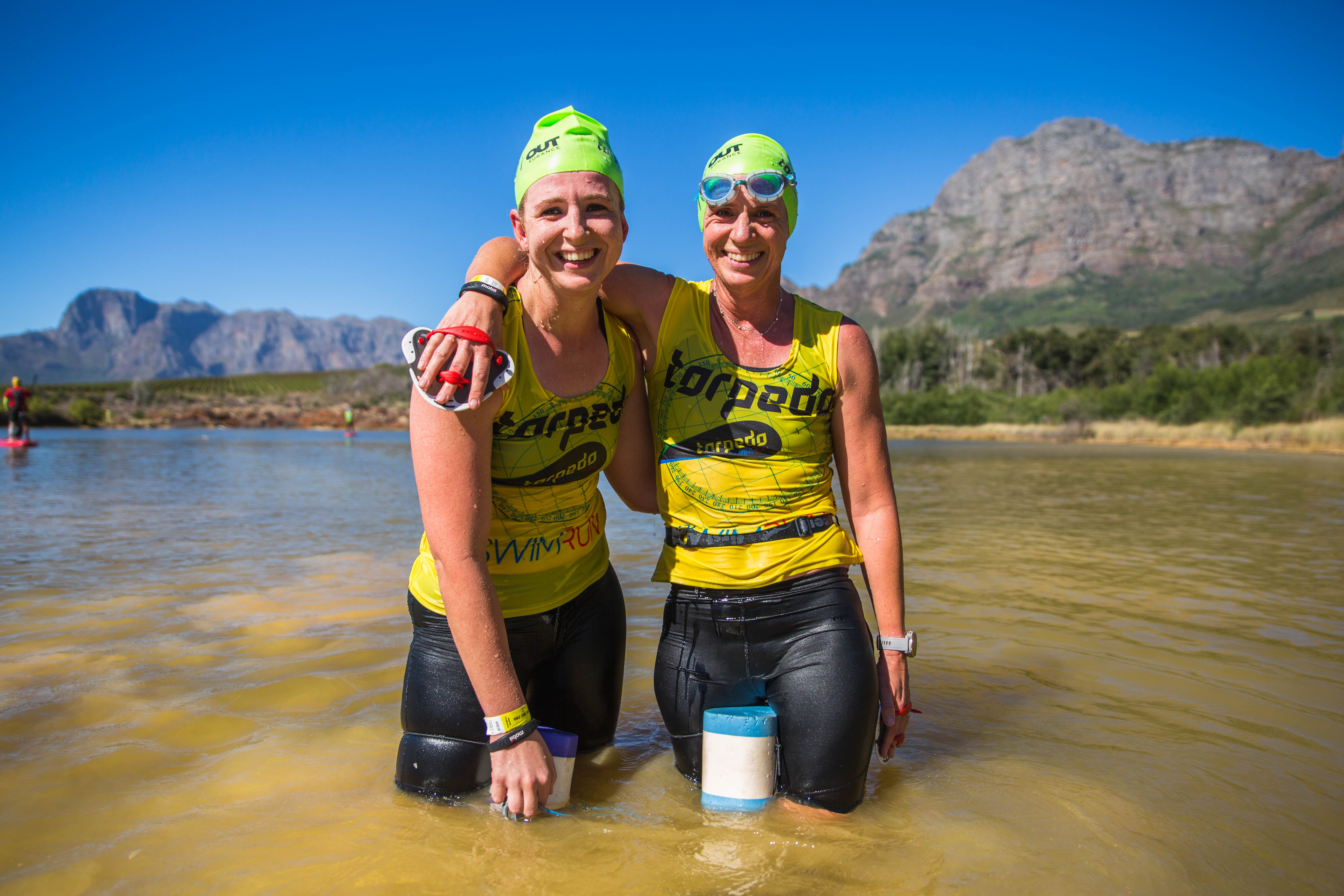 Two athletes smiling together in the dam post-race