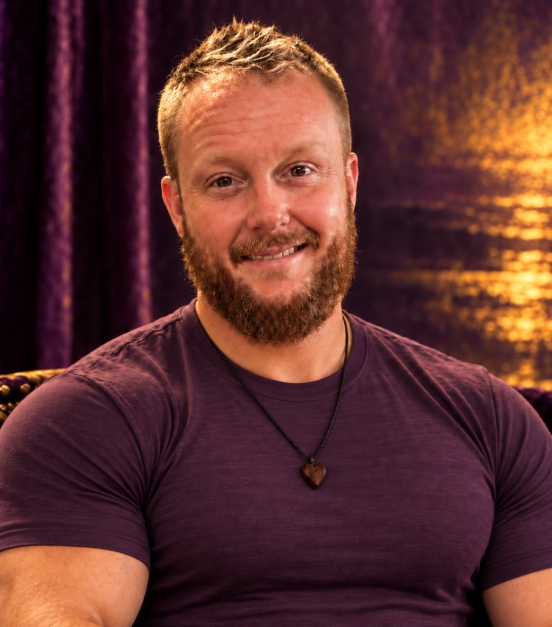 Joshua Long seated in a plum-colored shirt