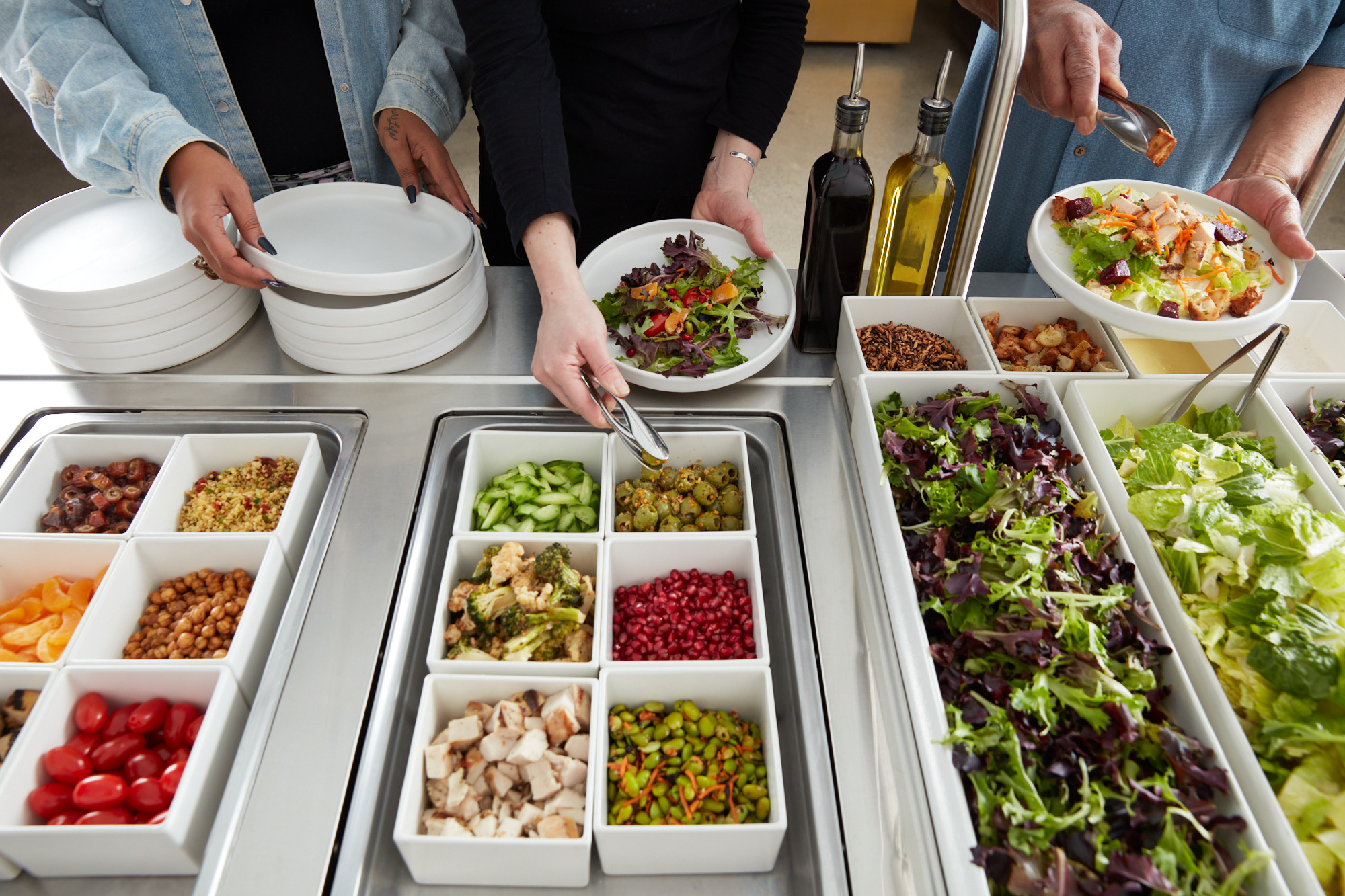 Salad bar with bins of fresh toppings and greens