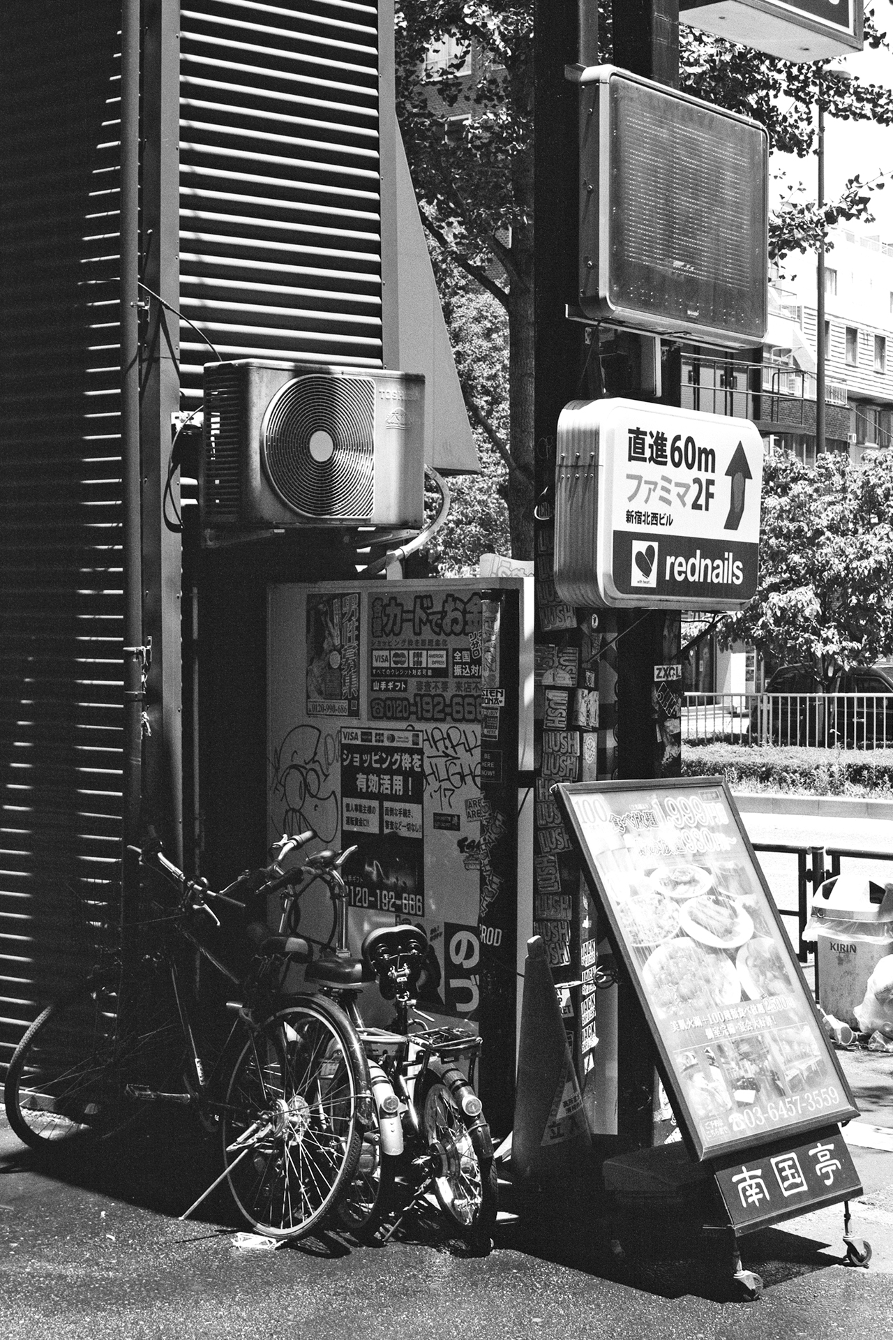 Black and white three Japanese vending machines Asahi DyDo Kirin soft drinks lined up street