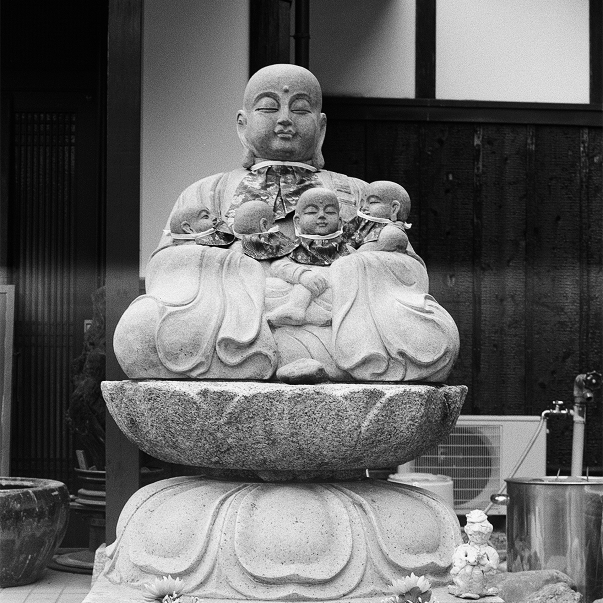 Black and white ornate vintage metal mailbox with coat of arms mounted on rough stone wall