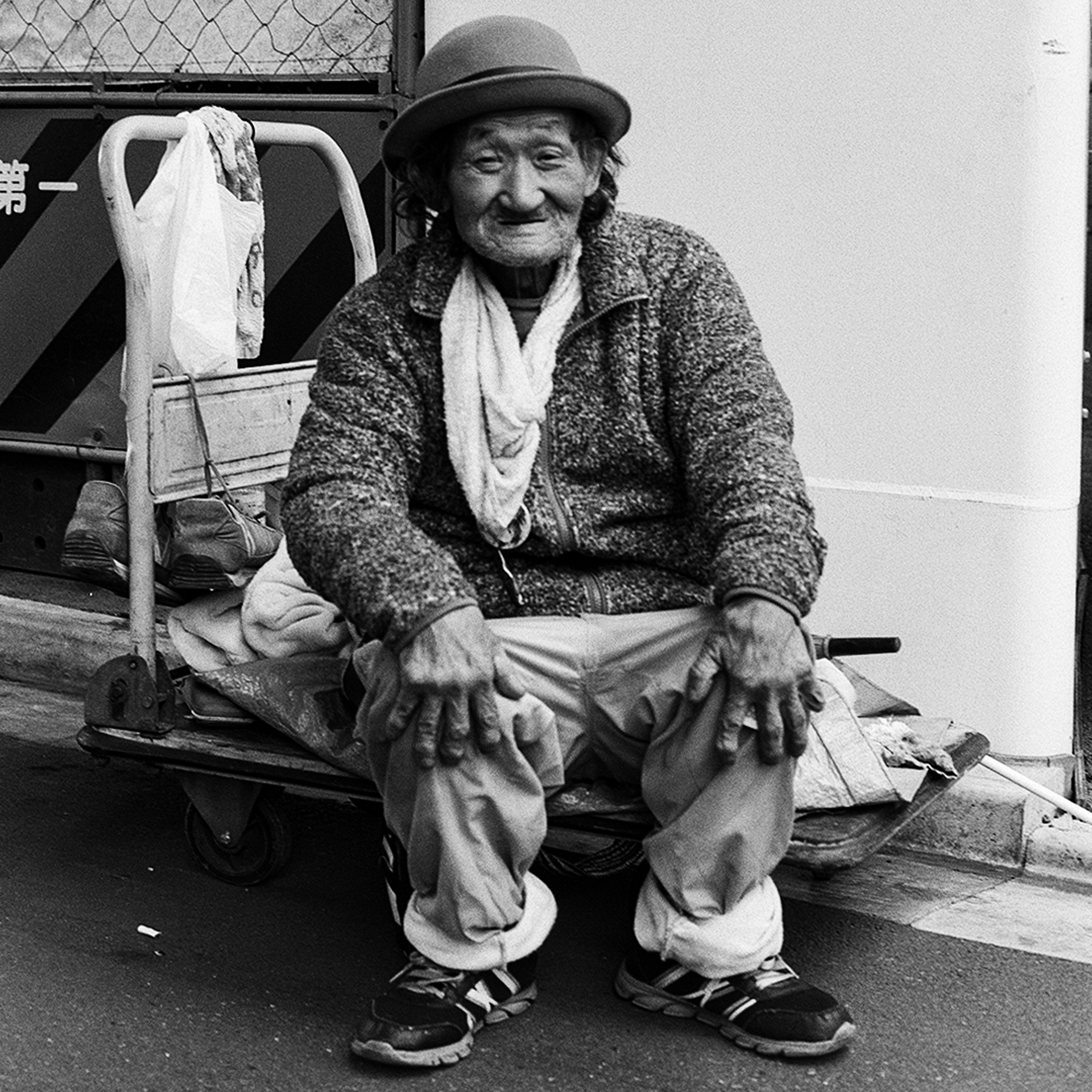 Black and white young market vendor smiling in traditional straw hat floral shirt apron