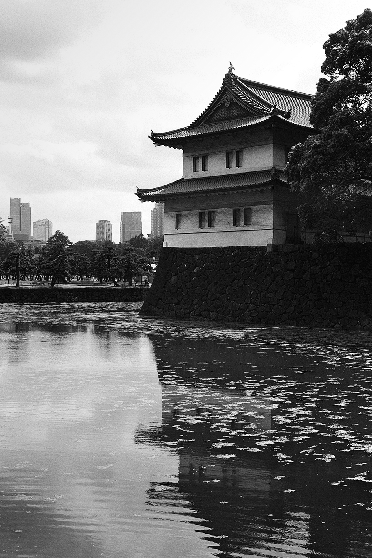 Black and white Imperial Palace watchtower over moat with Tokyo skyline traditional meets modern