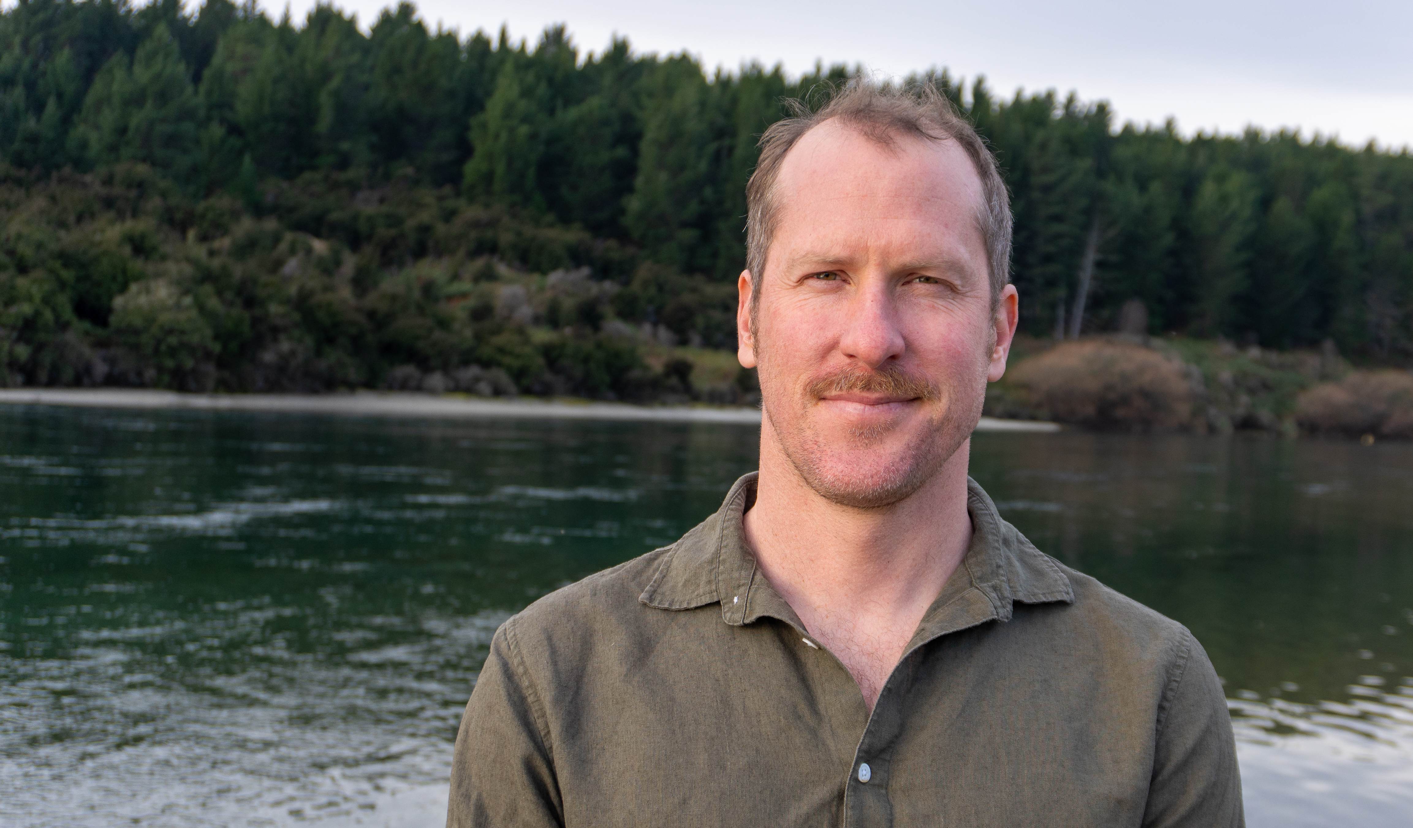 Portrait of Jeremy Platt, Principal for Product Development and Education at Pivot Innovation, standing by a New Zealand river