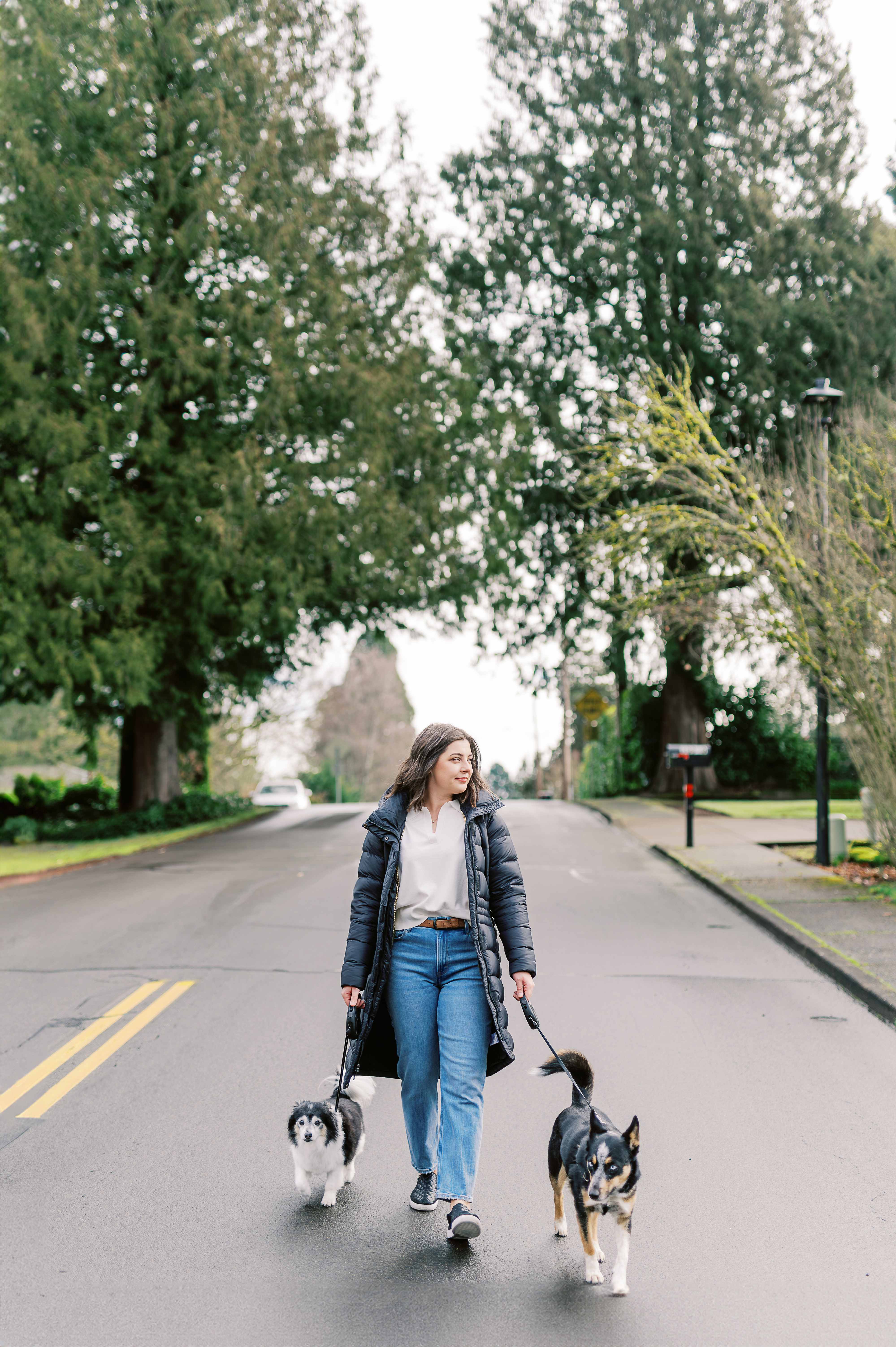 Jordyn walking her two dogs down a tree-lined street