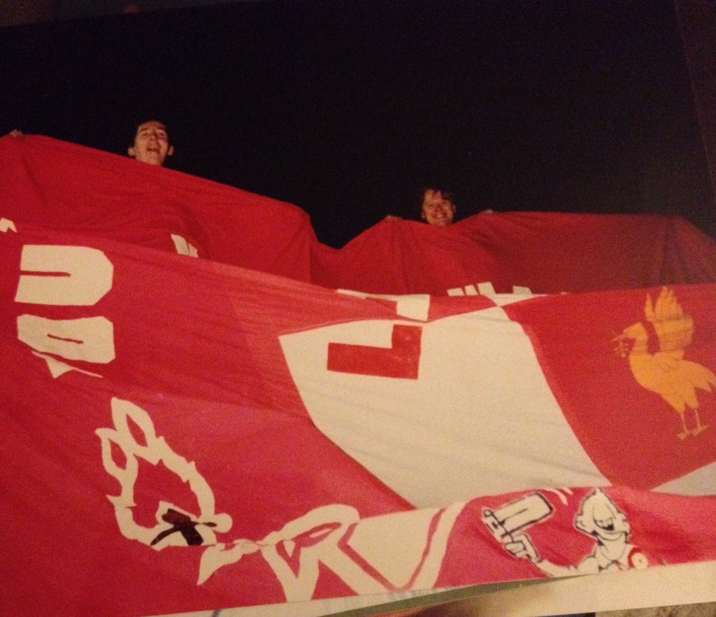 Fans holding up a large LFC flag at night