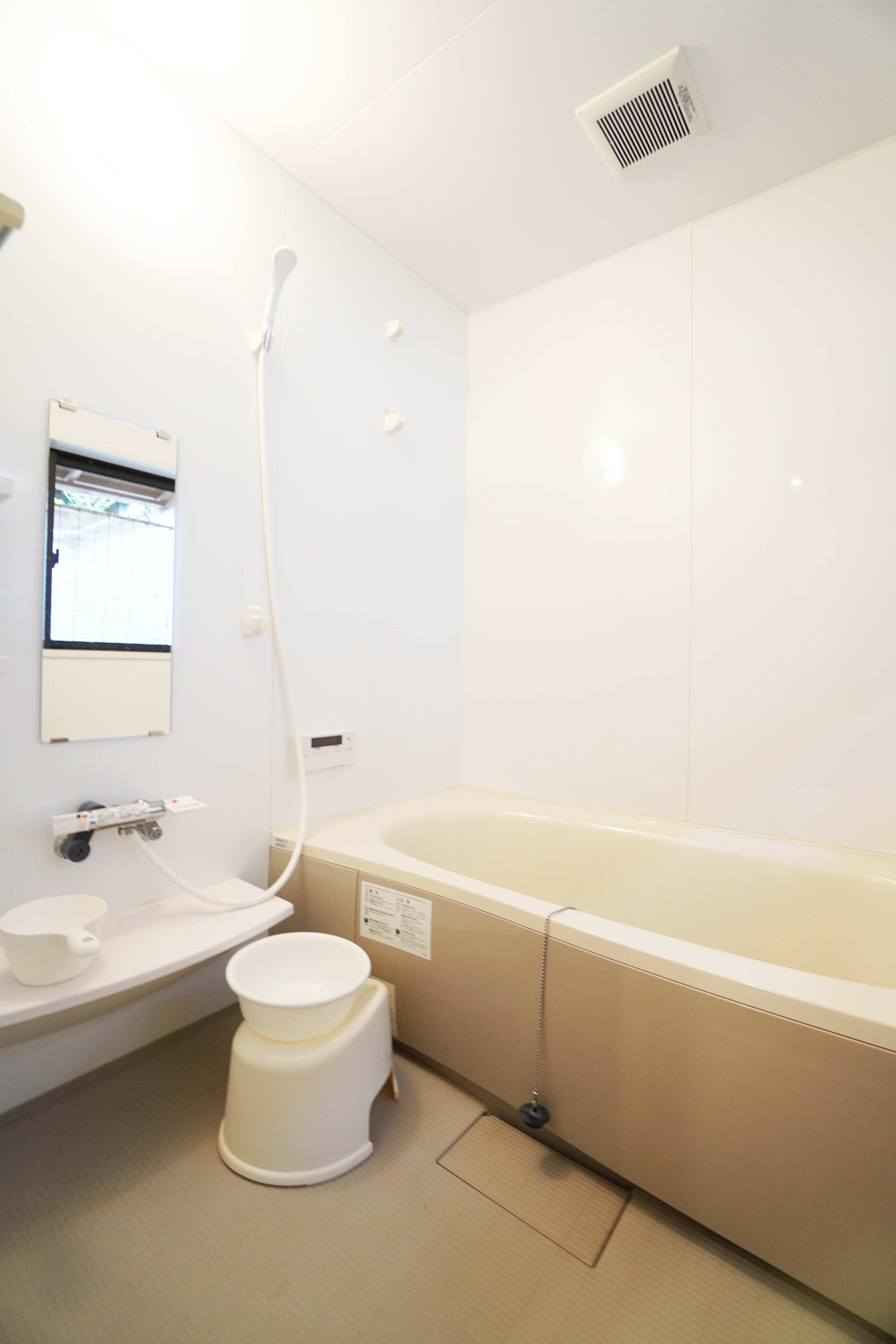 Clean Japanese bathroom with deep soaking tub and shower area