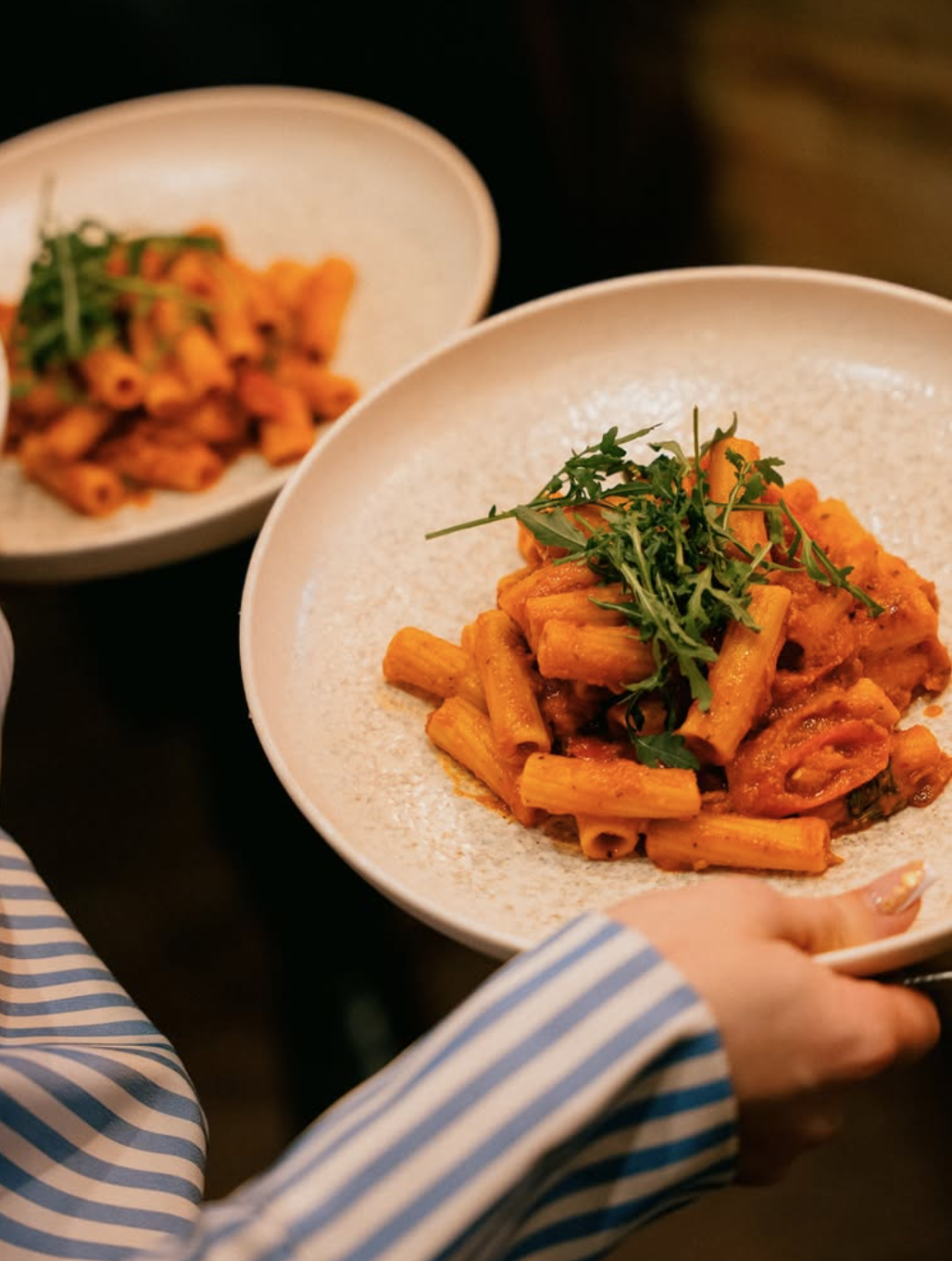 Rigatoni pasta with tomato sauce and fresh arugula