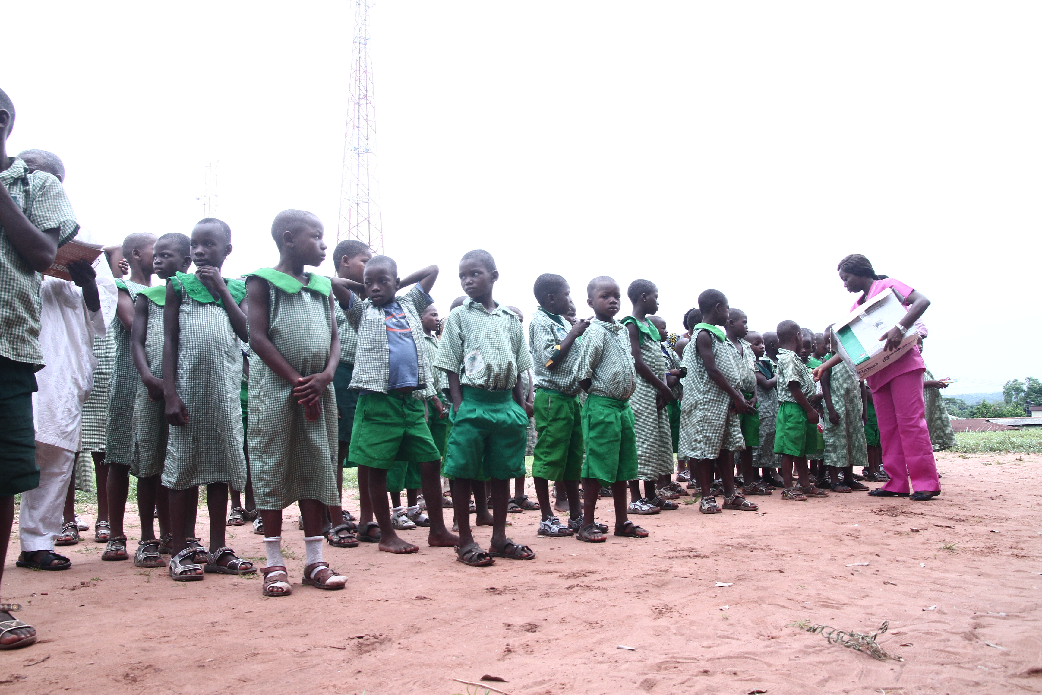 Children lined up receiving health education materials