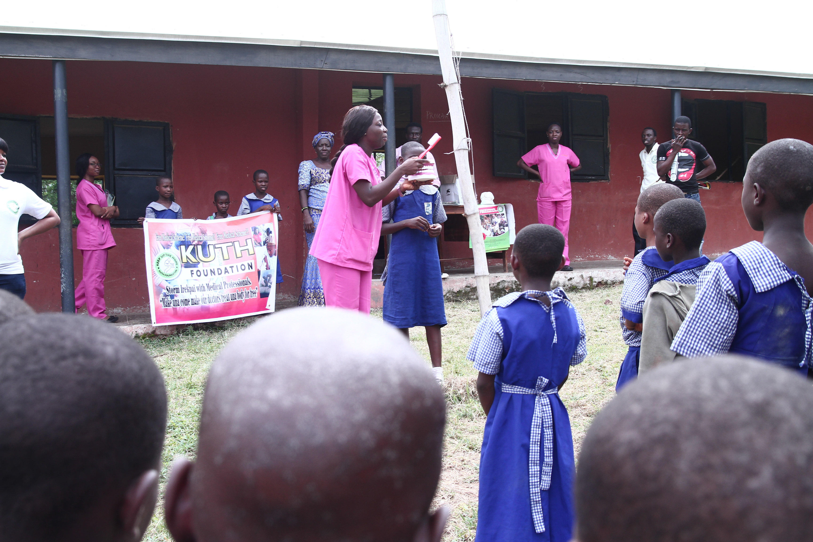 Nurse demonstrating dental hygiene with KUTH banner
