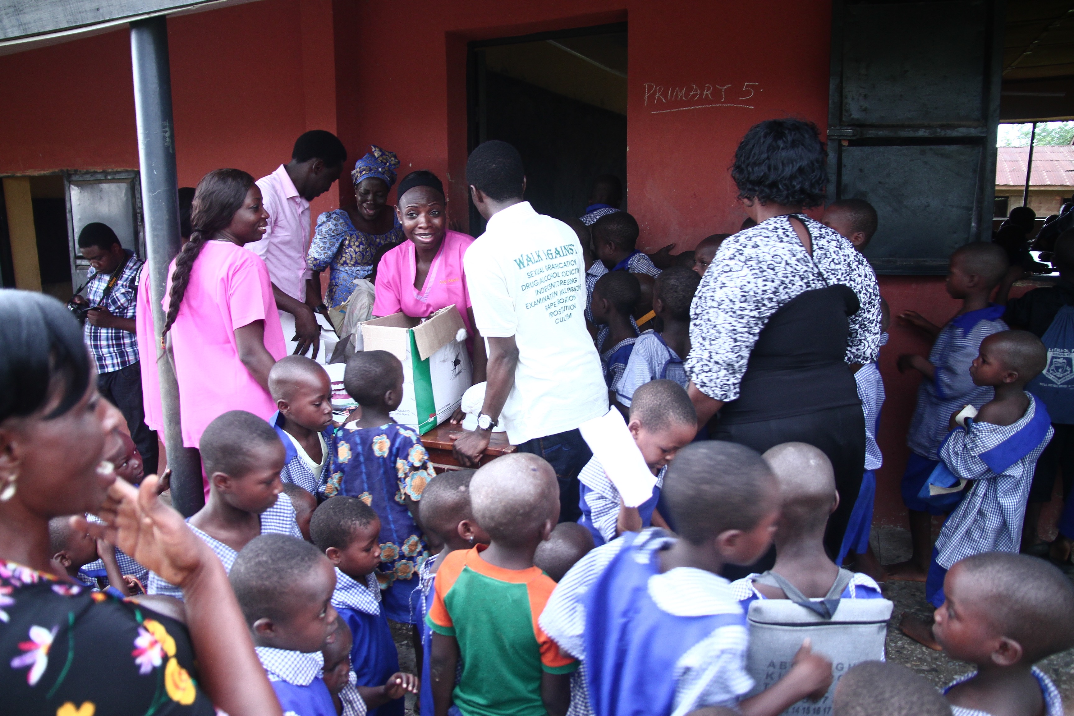 Team distributing materials to crowd of school children