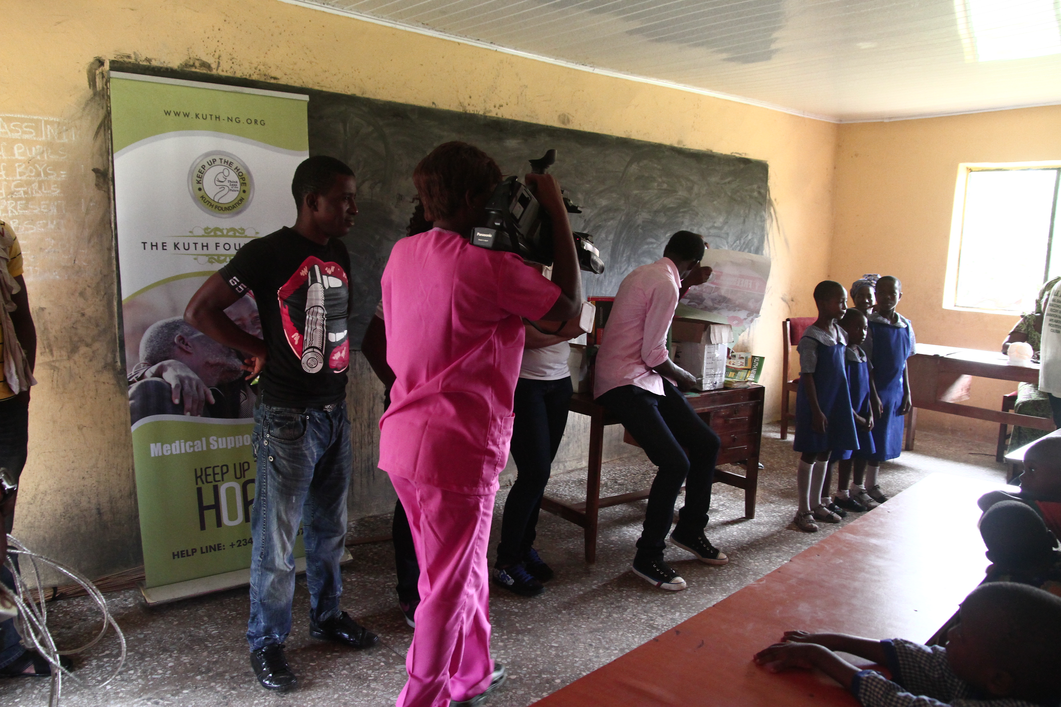 KUTH banner inside classroom with camera crew