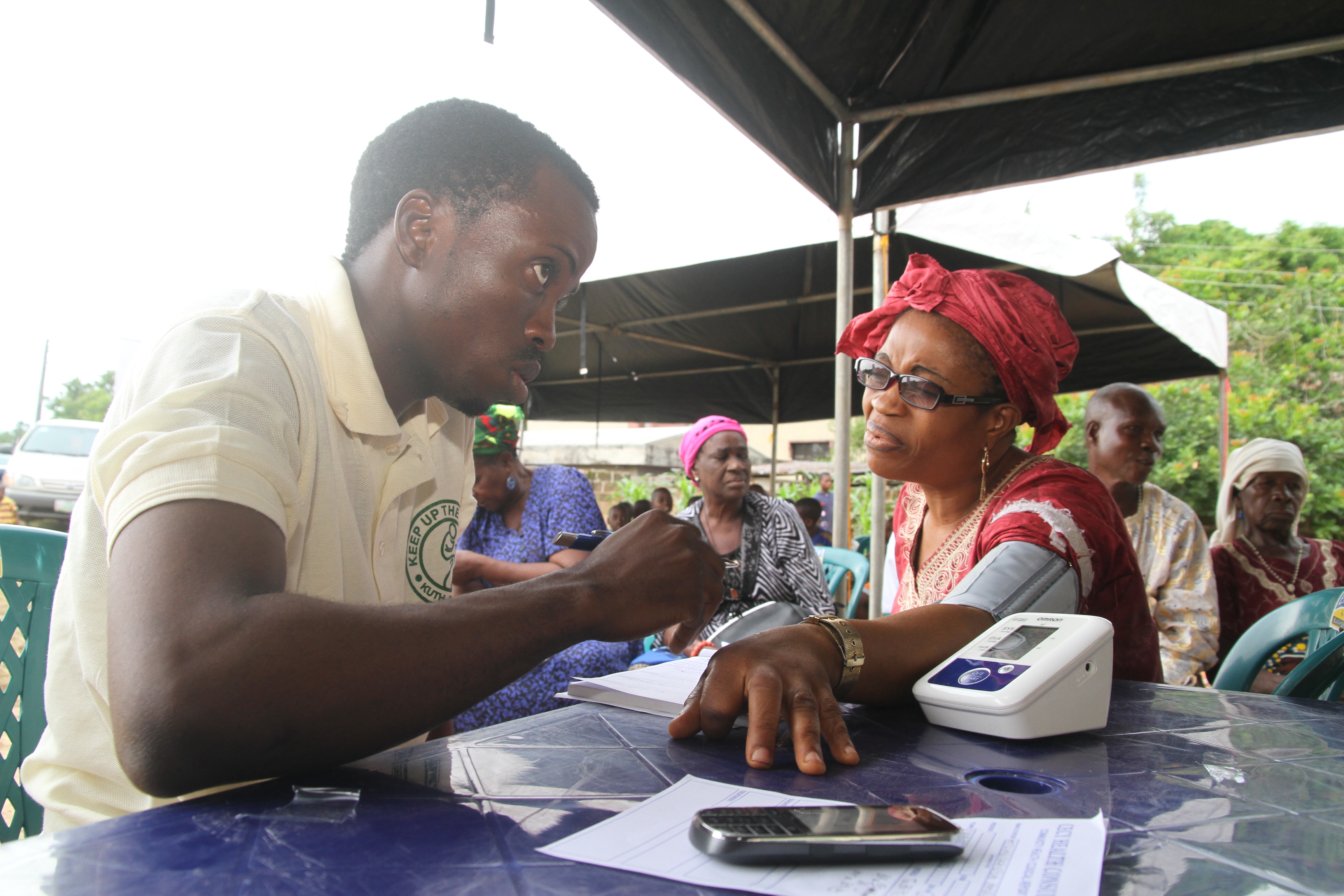 Blood pressure check with yellow polo team member