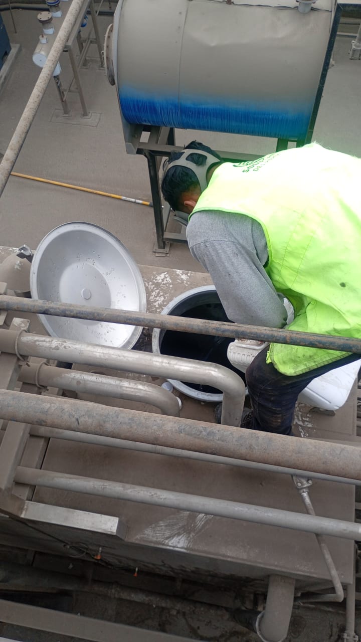 Trabajador limpiando isotanque de transporte de líquidos