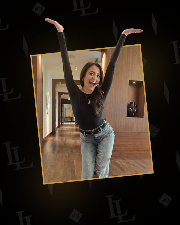 Francine — Lady Luck HQ — celebrating with arms raised in a luxury hotel hallway