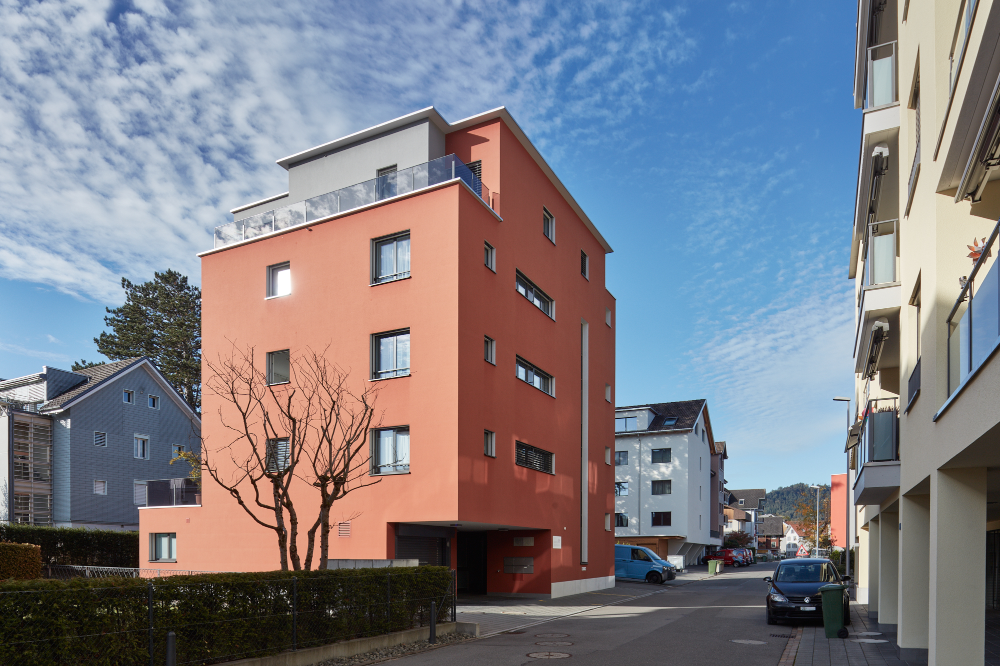 Korallenrotes Mehrfamilienhaus in einer Wohnstrasse