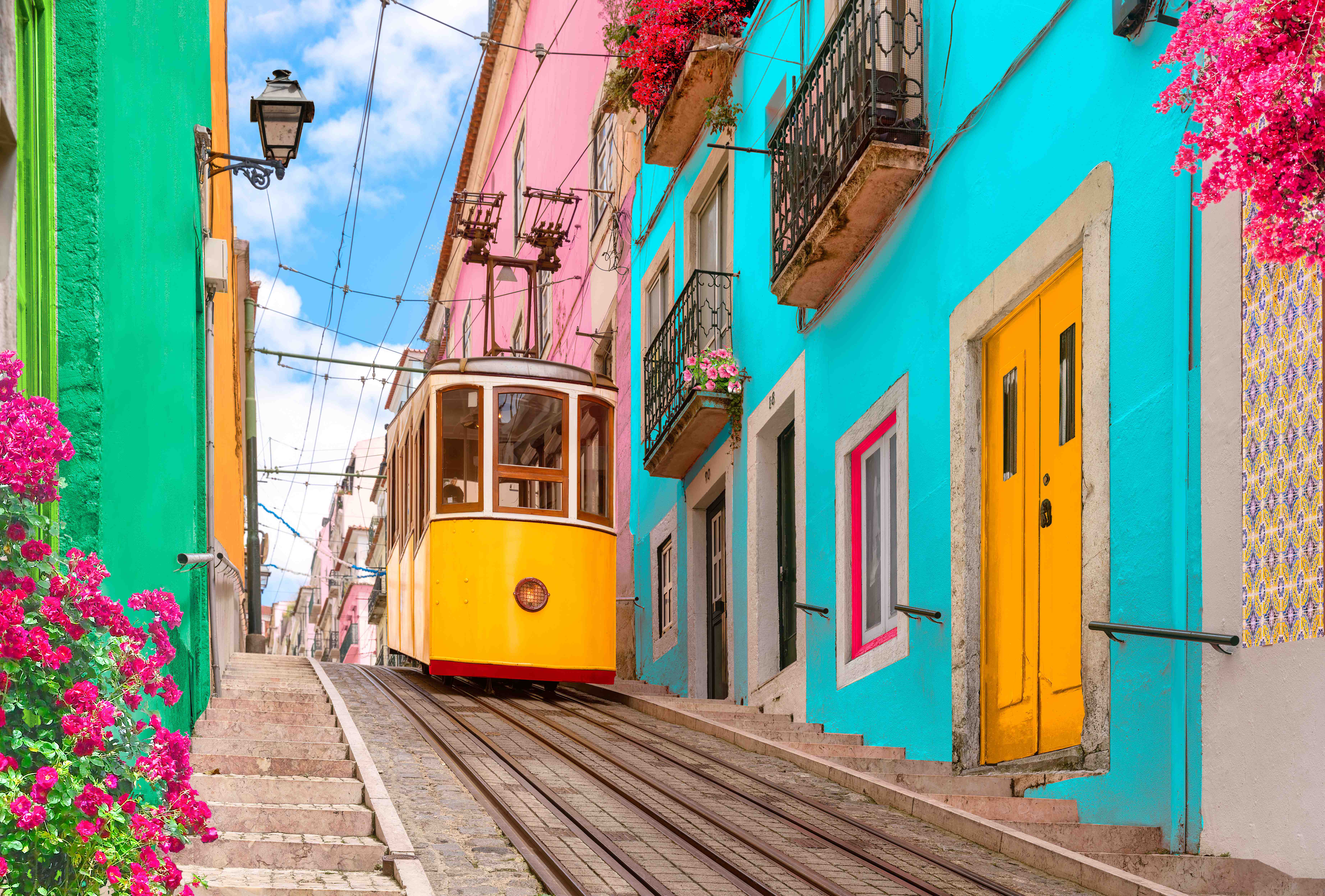 Lissabon – Bunte historische Gasse mit gelber Straßenbahn und Blüten