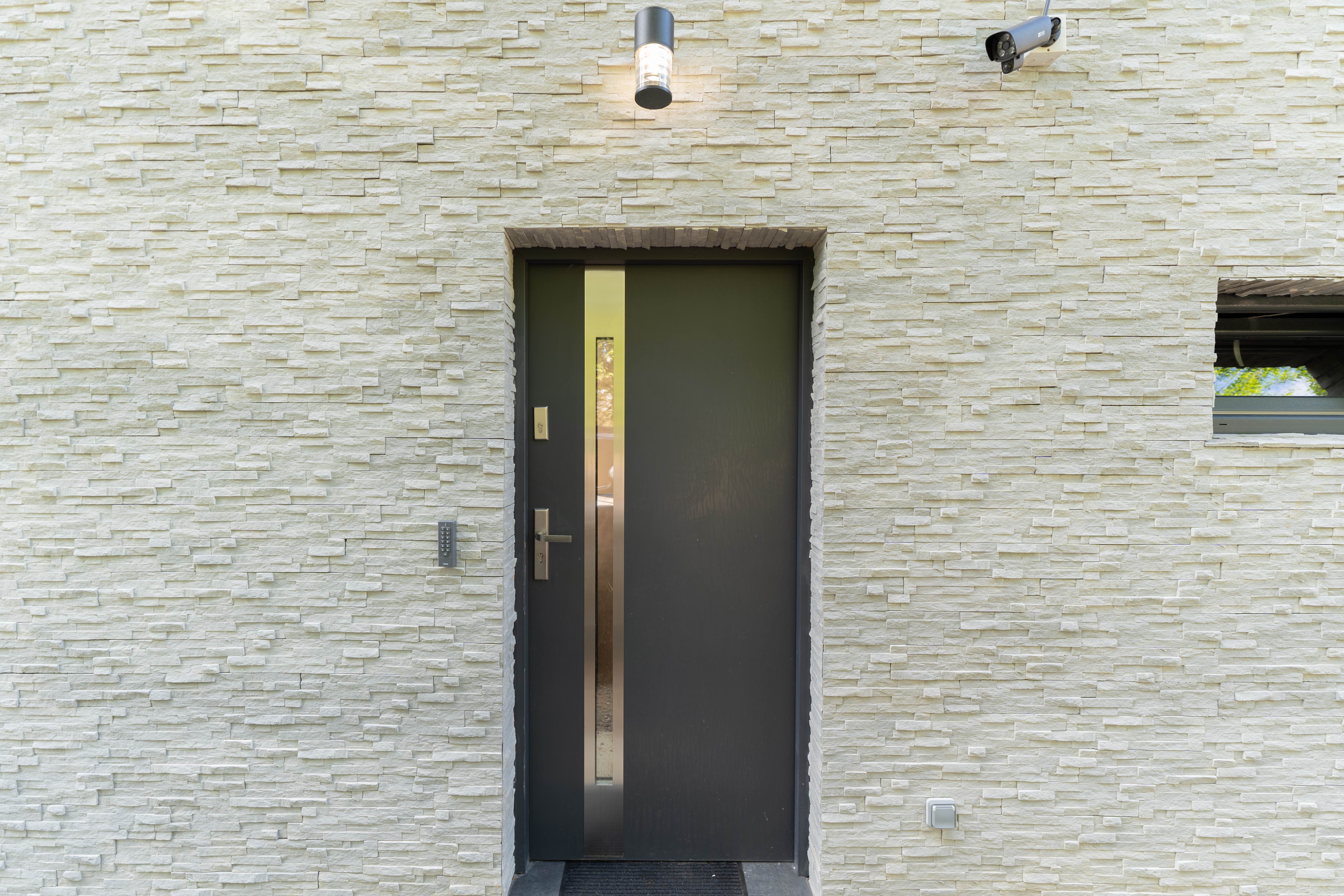 Entrance door with stone cladding