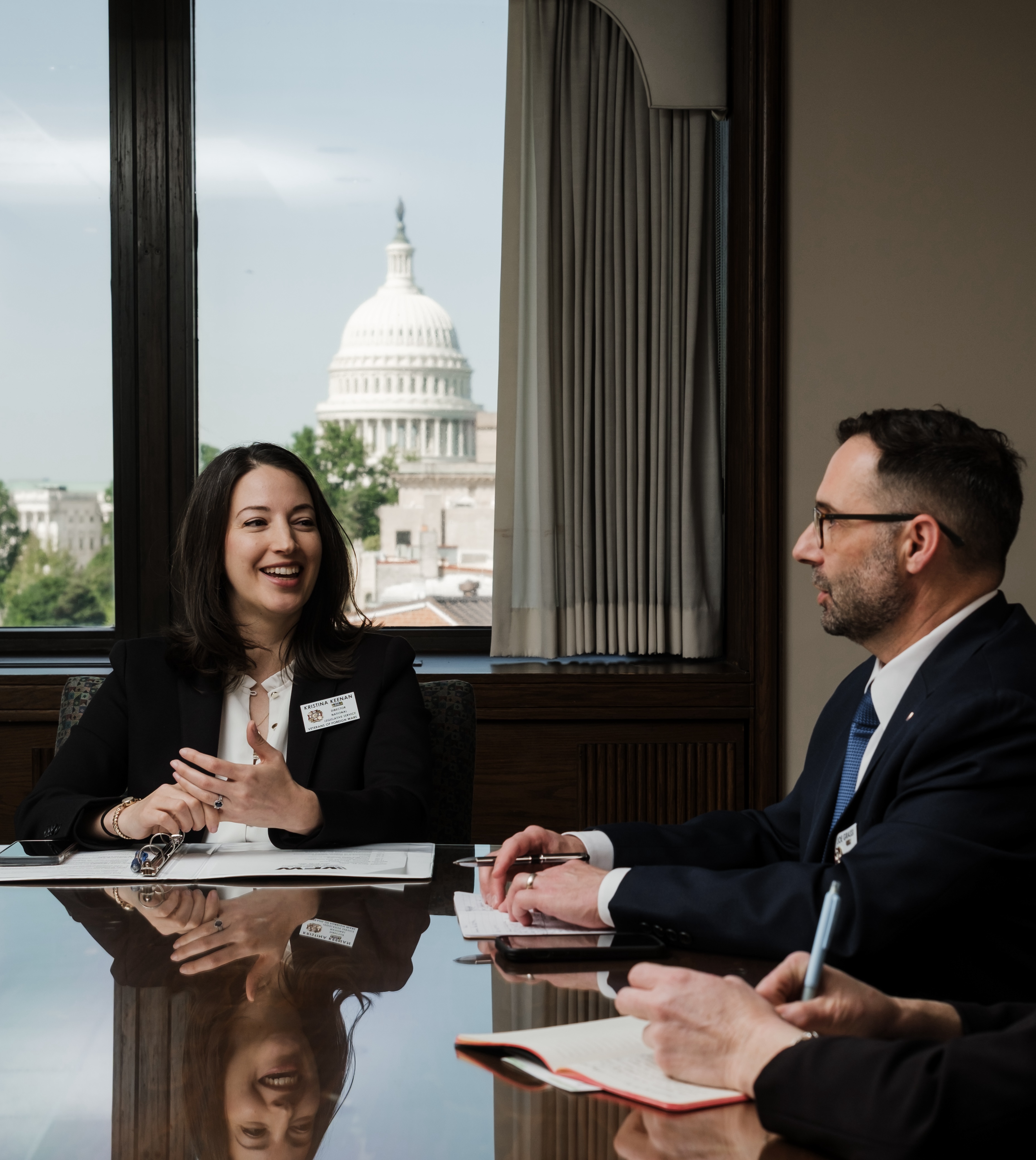 VFW Foundation staff member speaking with partners in a Washington D.C. office, U.S. Capitol visible through the window