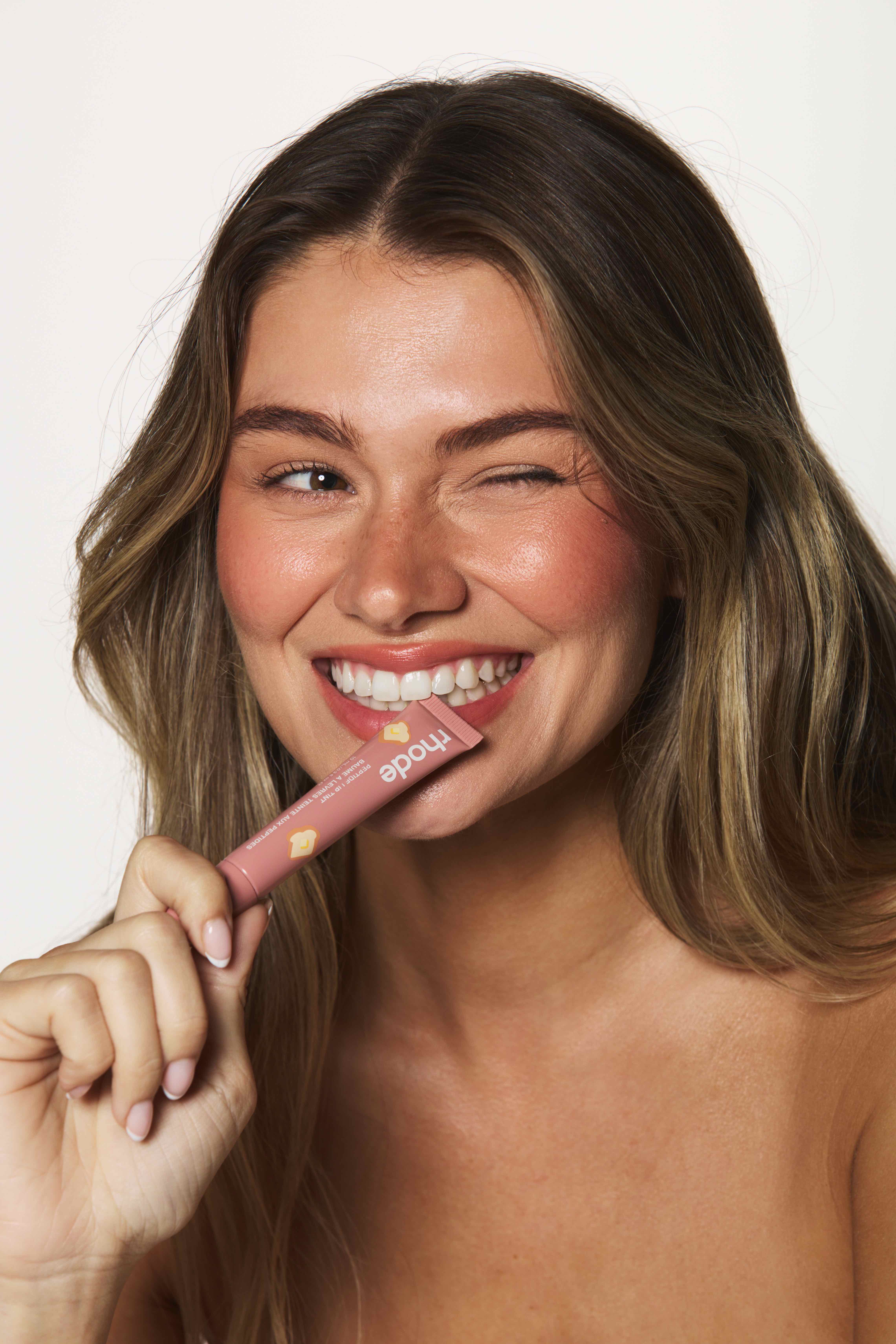Mollie smiling biting Rhode lip tint playful